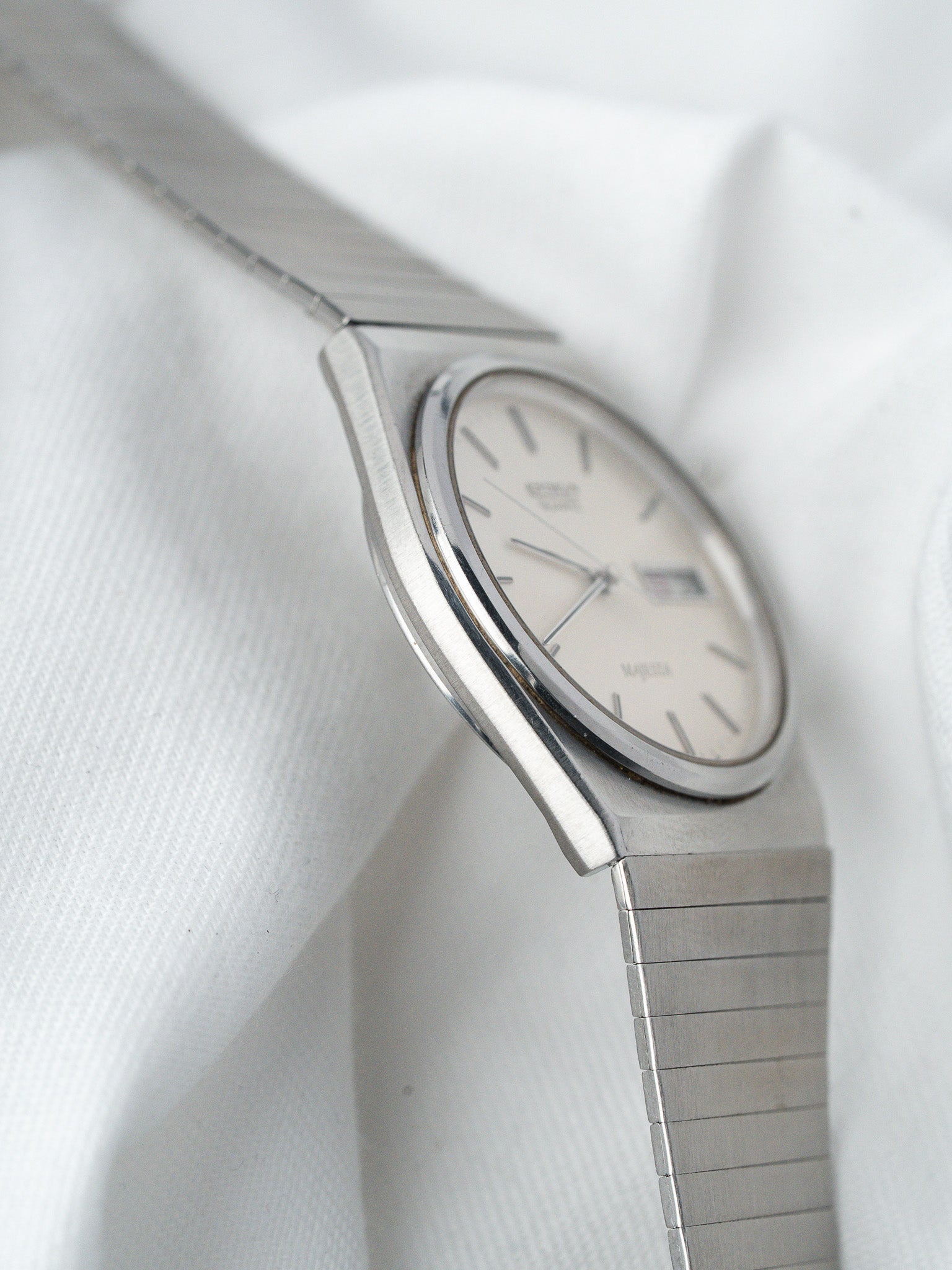 Omega Seamaster vintage watch with silver dial and steel bracelet on white fabric