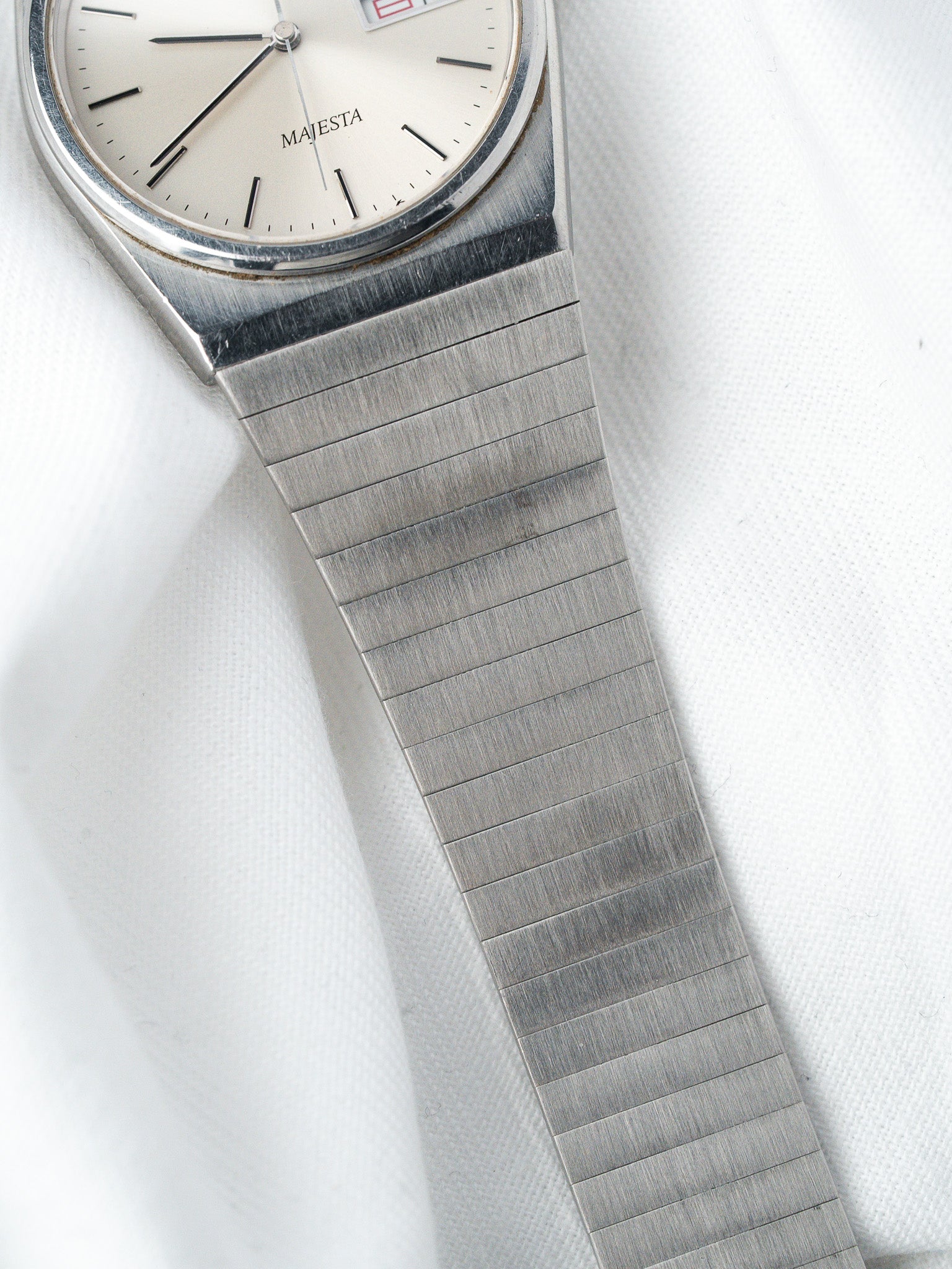 Majesta vintage watch with silver dial, steel bracelet, on white fabric background