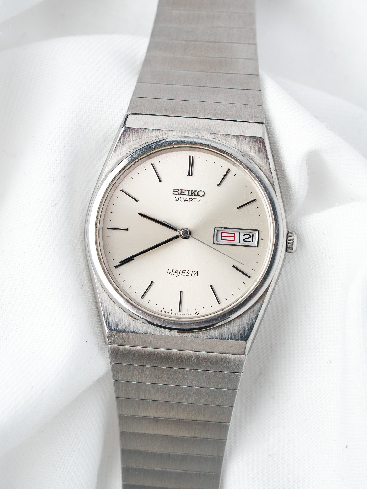 Seiko Majesta vintage quartz watch with silver dial, date window, and steel bracelet on white fabric