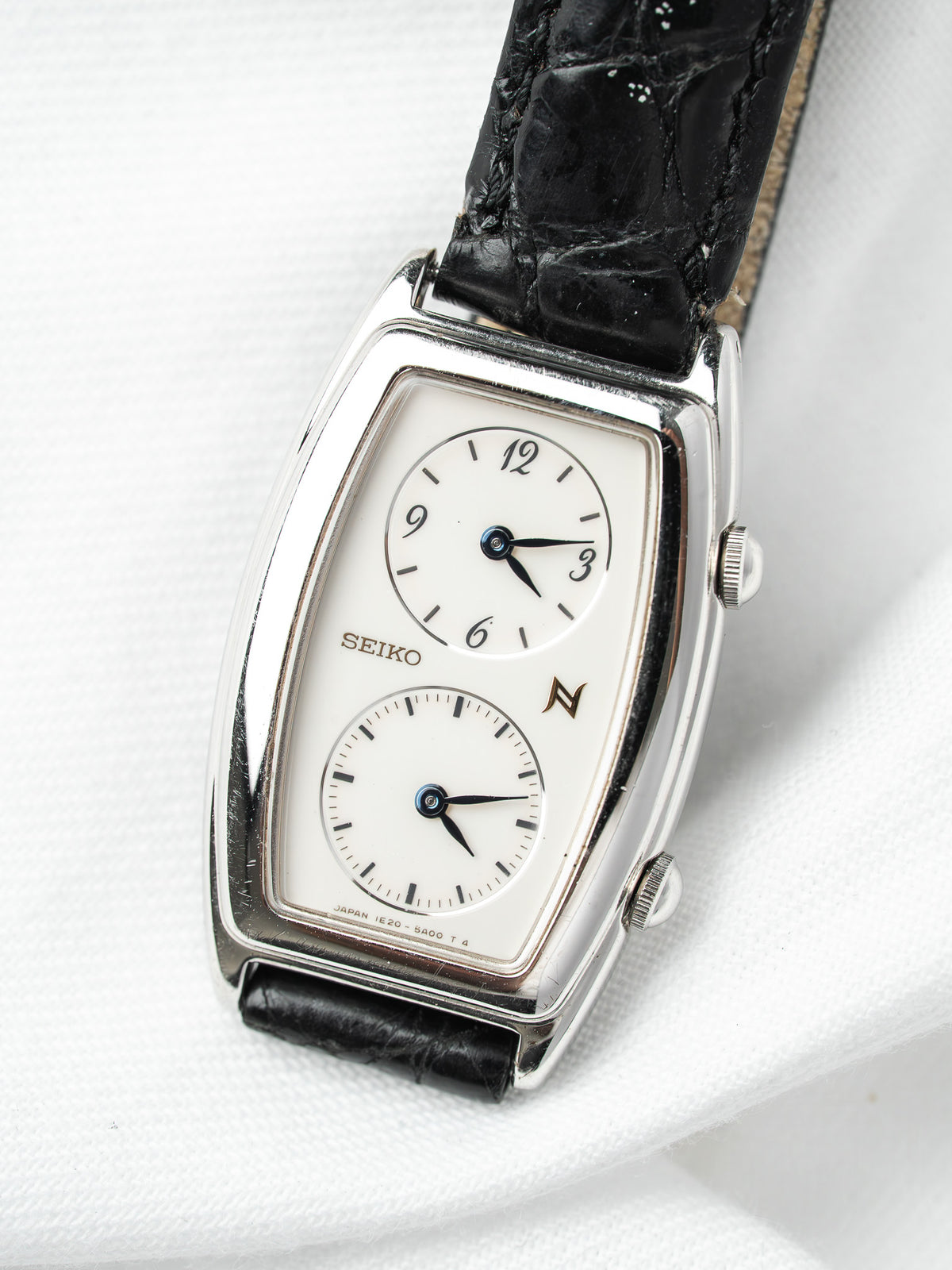 Seiko vintage watch with white dial, black leather strap, and silver case