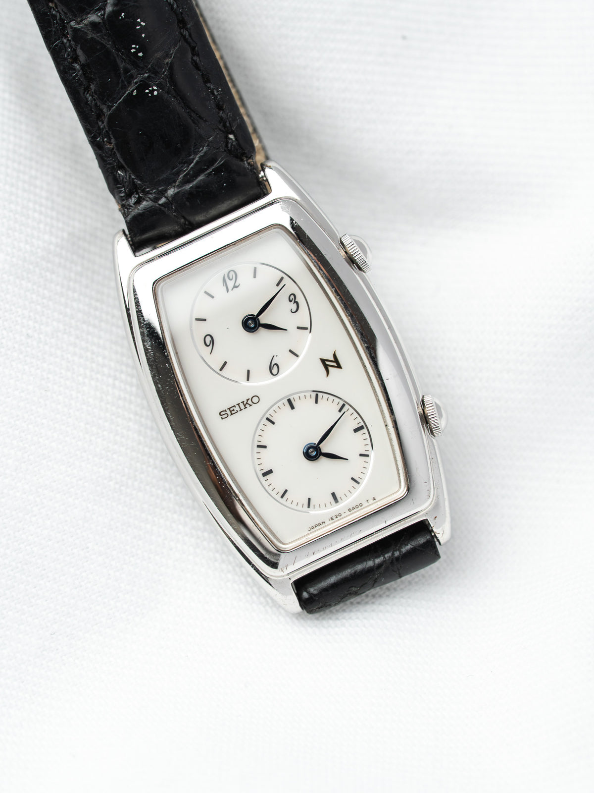 Seiko vintage watch with white dial, black leather strap, and silver case