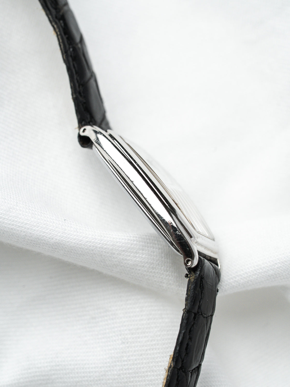 Vintage Cartier Tank watch with black alligator strap and polished steel case side view