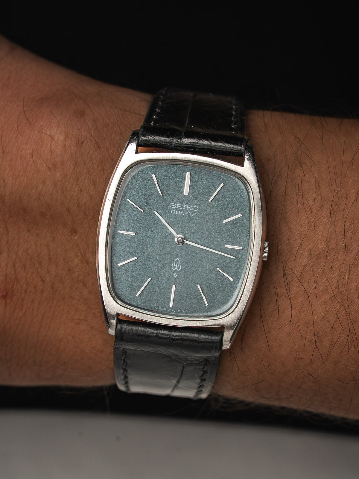 Montre Seiko Quartz vintage avec cadran bleu gris et bracelet en cuir noir.