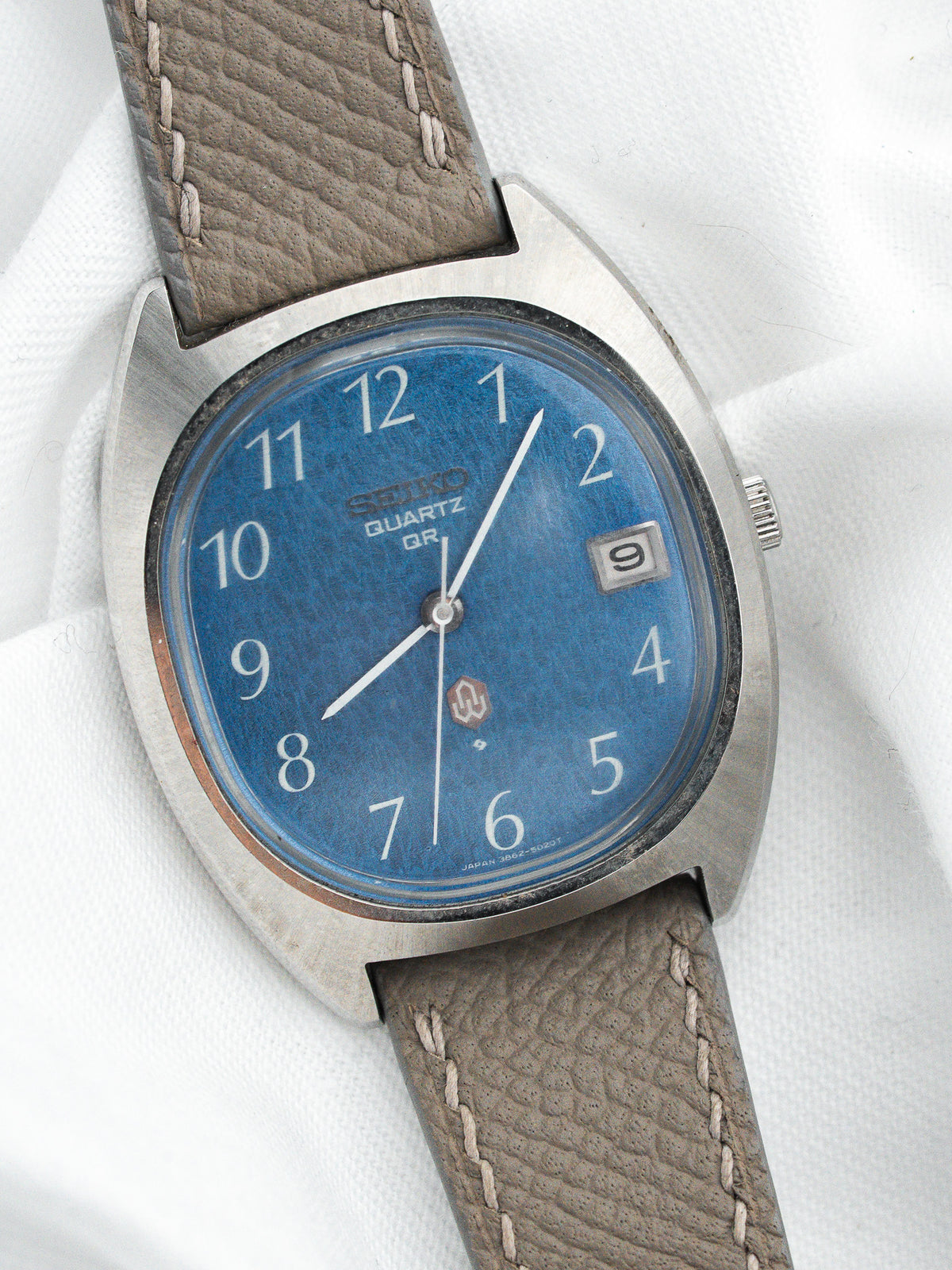 Montre Seiko Quartz vintage en acier, cadran bleu et bracelet en cuir gris