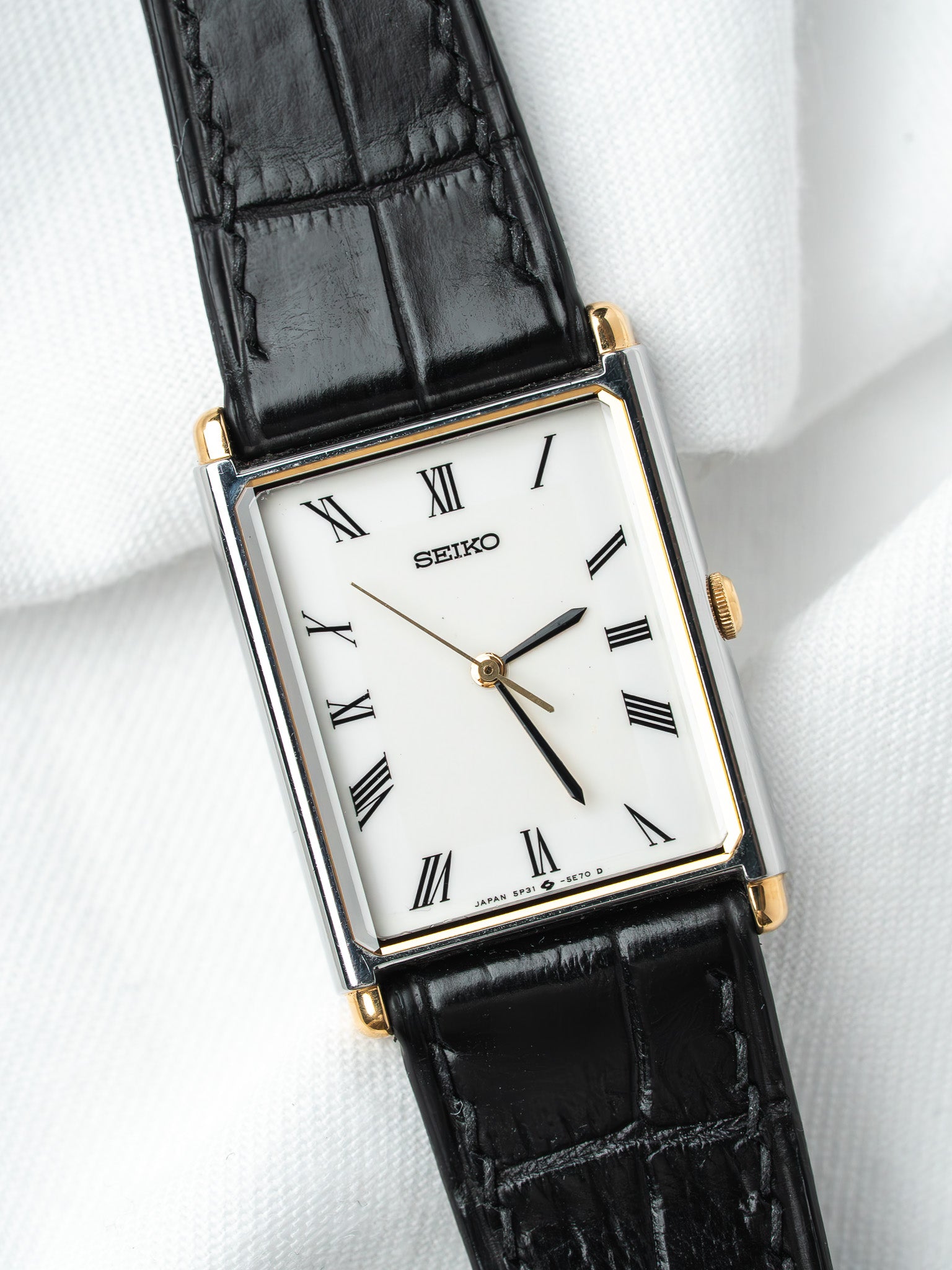 Seiko vintage watch with white dial, Roman numerals, black alligator strap, gold accents