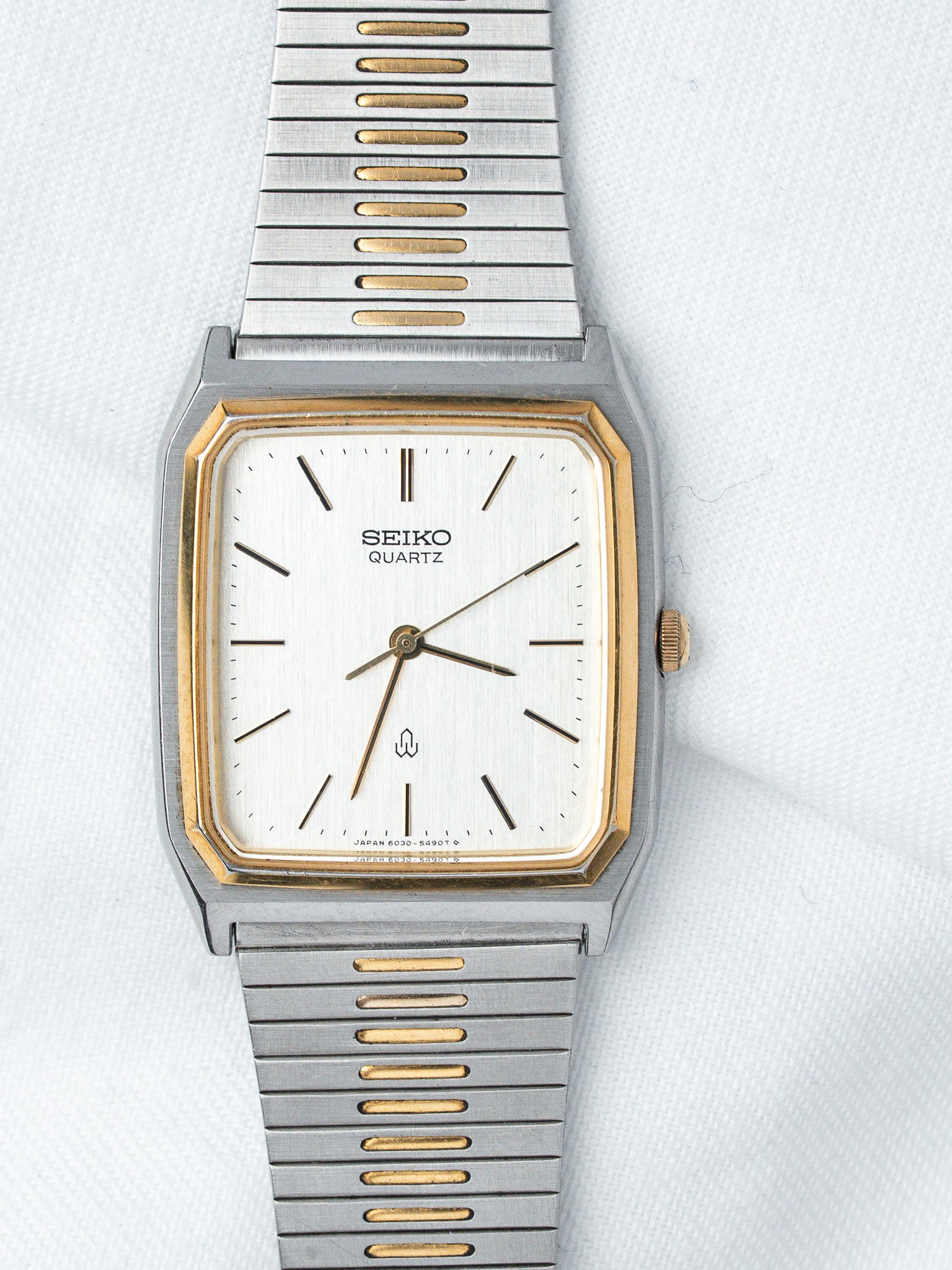 Seiko Quartz vintage watch with white dial, gold accents, and two-tone metal bracelet