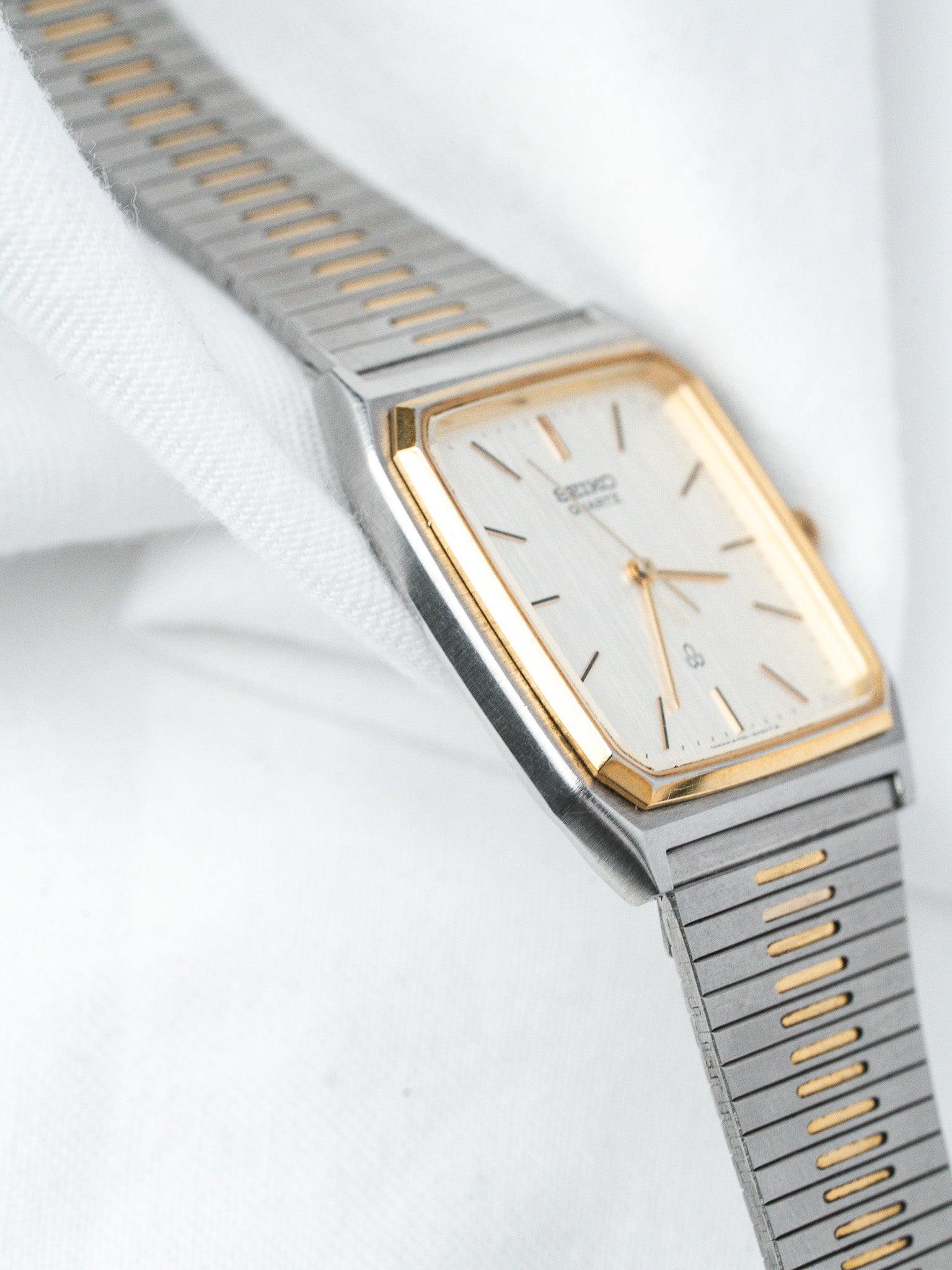 Seiko vintage watch with gold bezel, silver dial, and two-tone metal bracelet