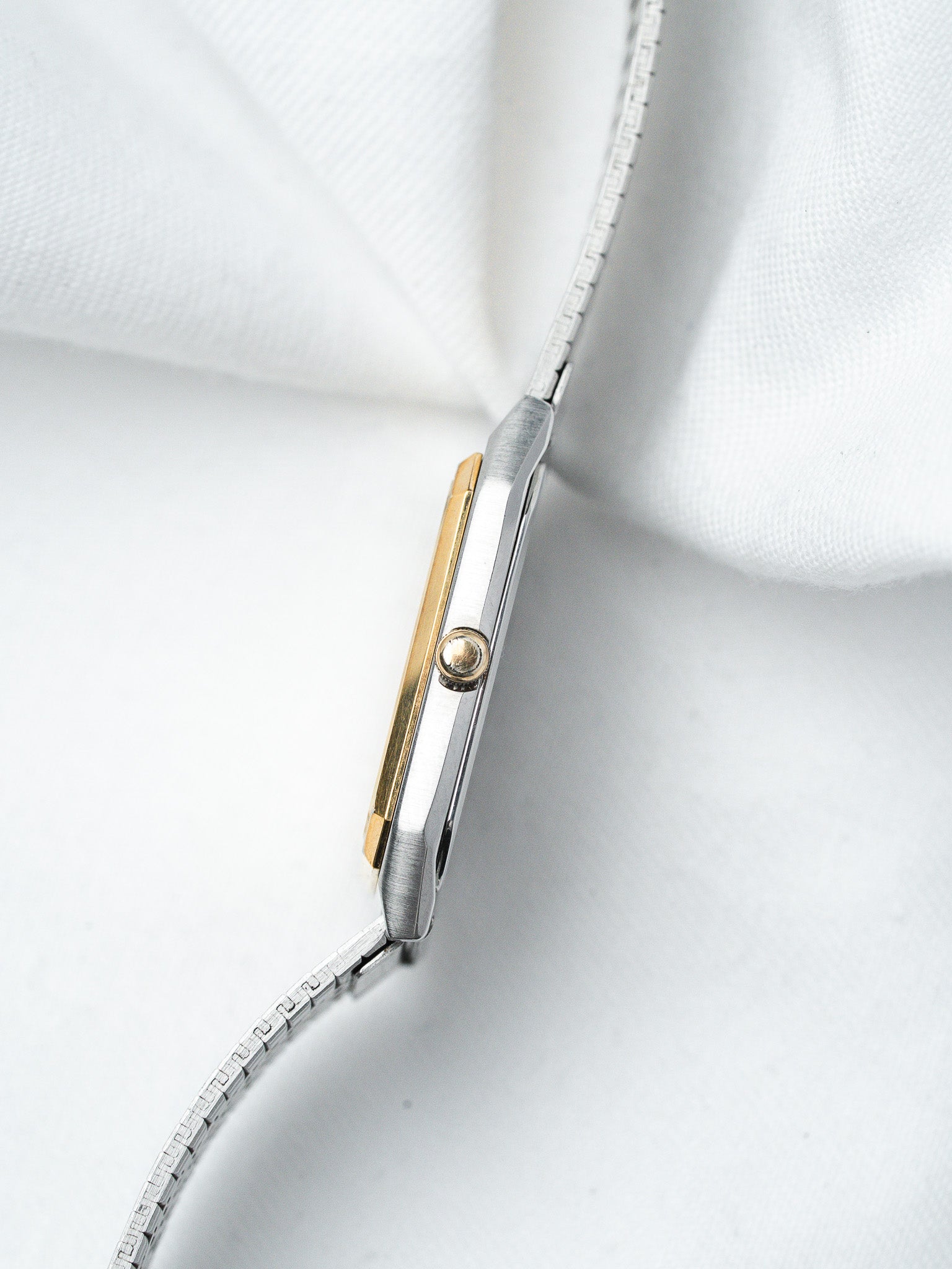 Vintage Cartier watch with two-tone gold and steel case, mesh bracelet on white fabric