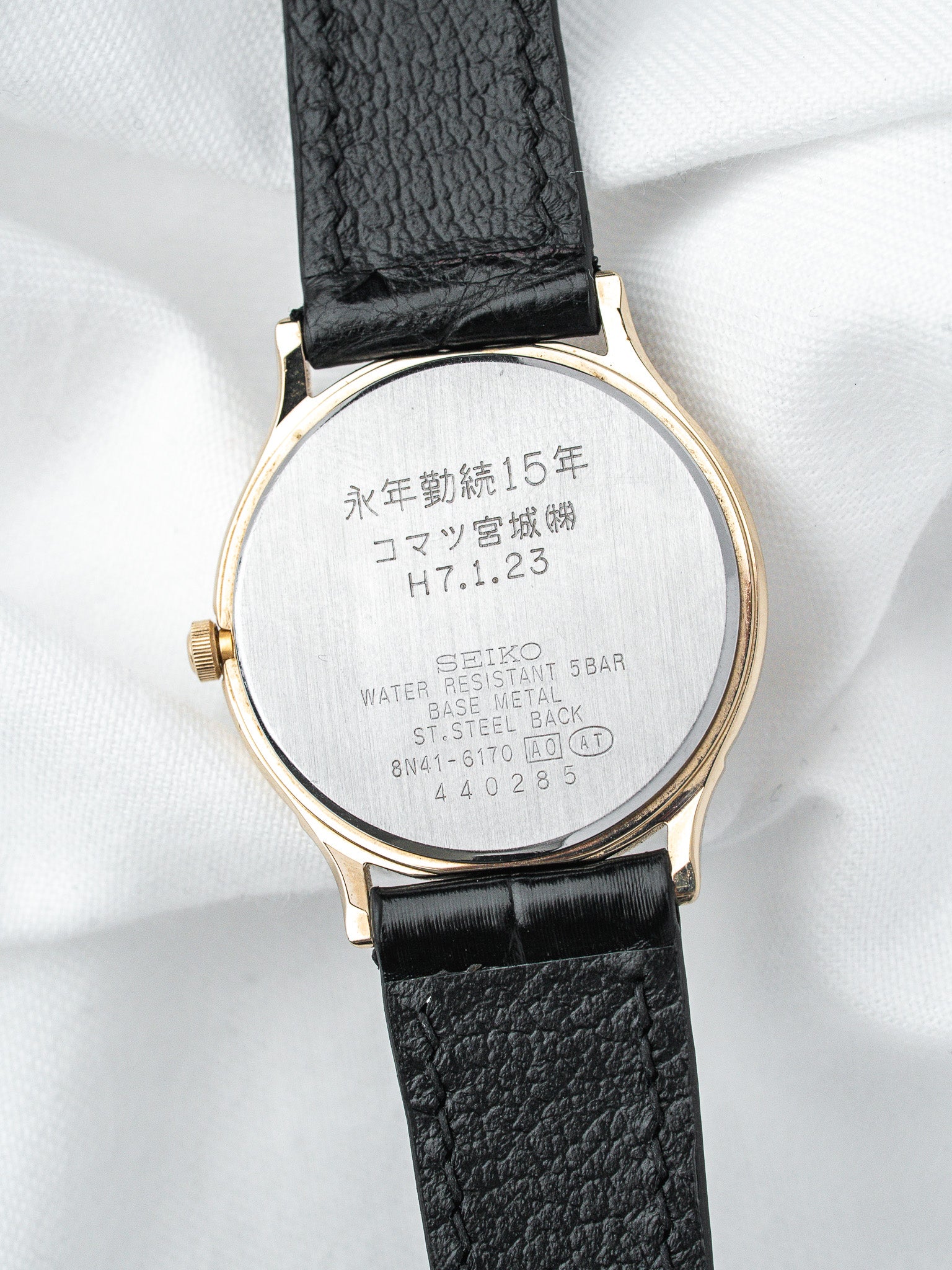 Seiko vintage watch back with gold case, black leather strap, Japanese engraving visible