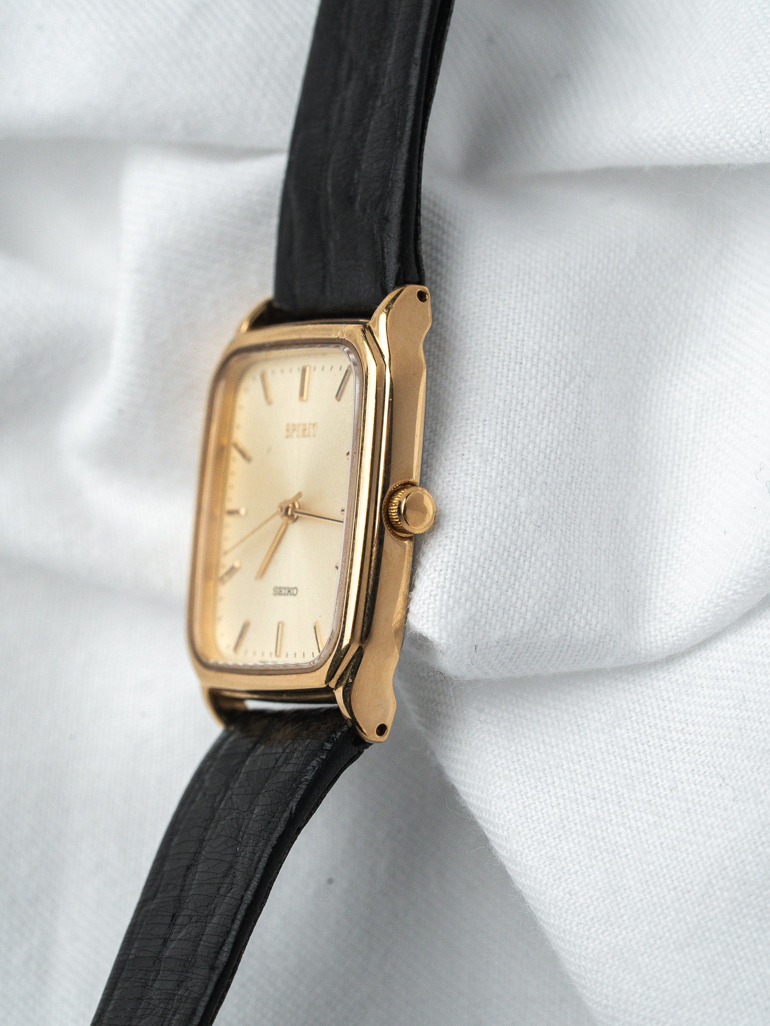 Seiko Spirit vintage watch with gold case, cream dial, and black leather strap