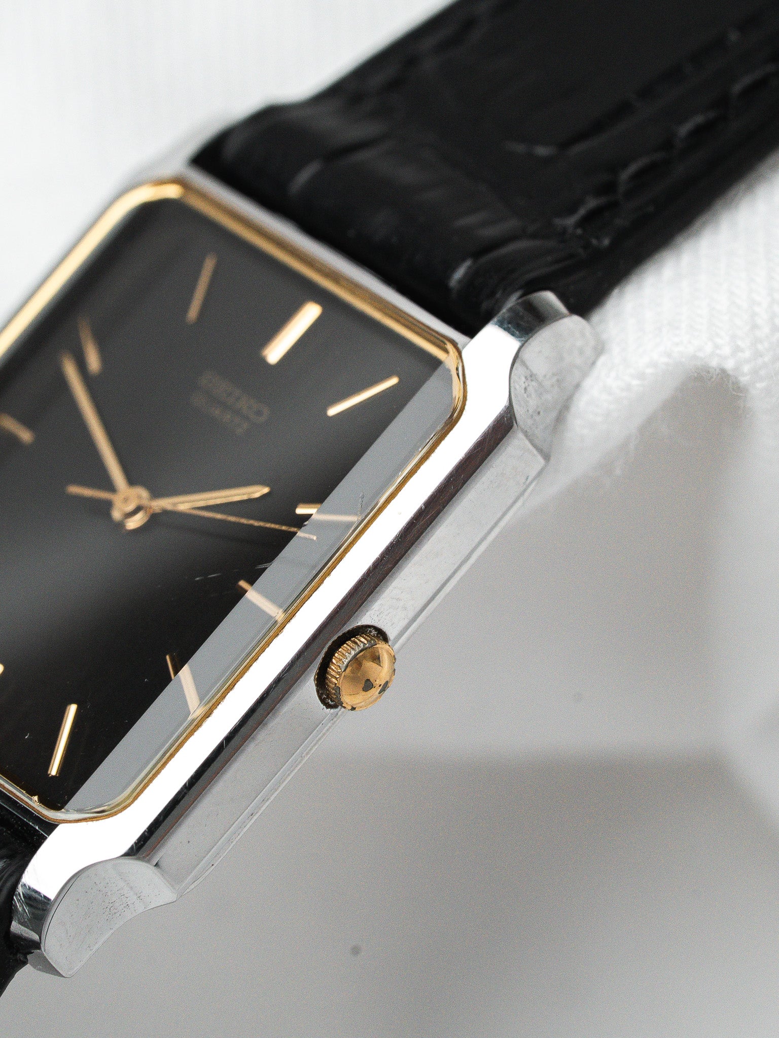 Cartier vintage watch with black dial, gold markers, and black leather strap