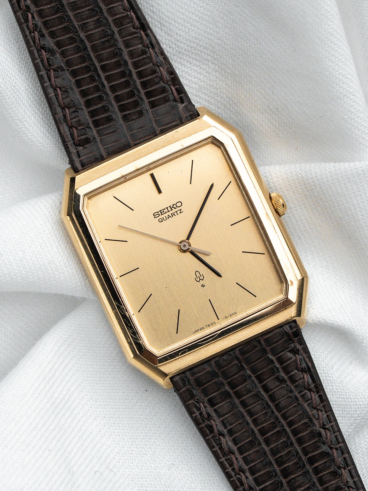Montre Seiko Quartz vintage, boîtier rectangulaire doré, cadran champagne et bracelet cuir brun