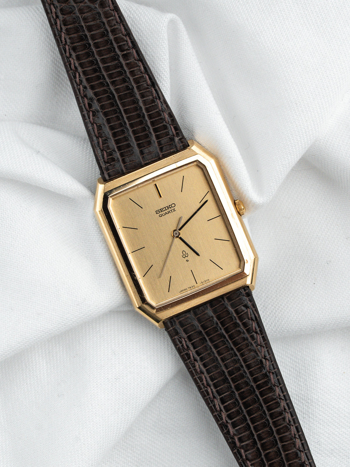 Montre Seiko Quartz vintage, boîtier carré doré, cadran champagne et bracelet cuir marron