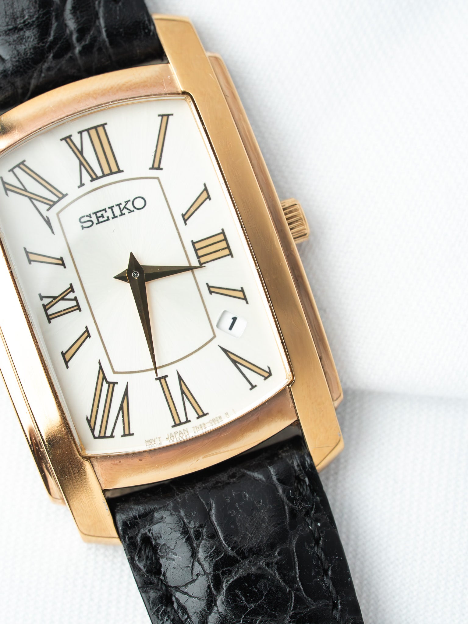 Seiko vintage watch with gold case, white dial, Roman numerals, black alligator strap