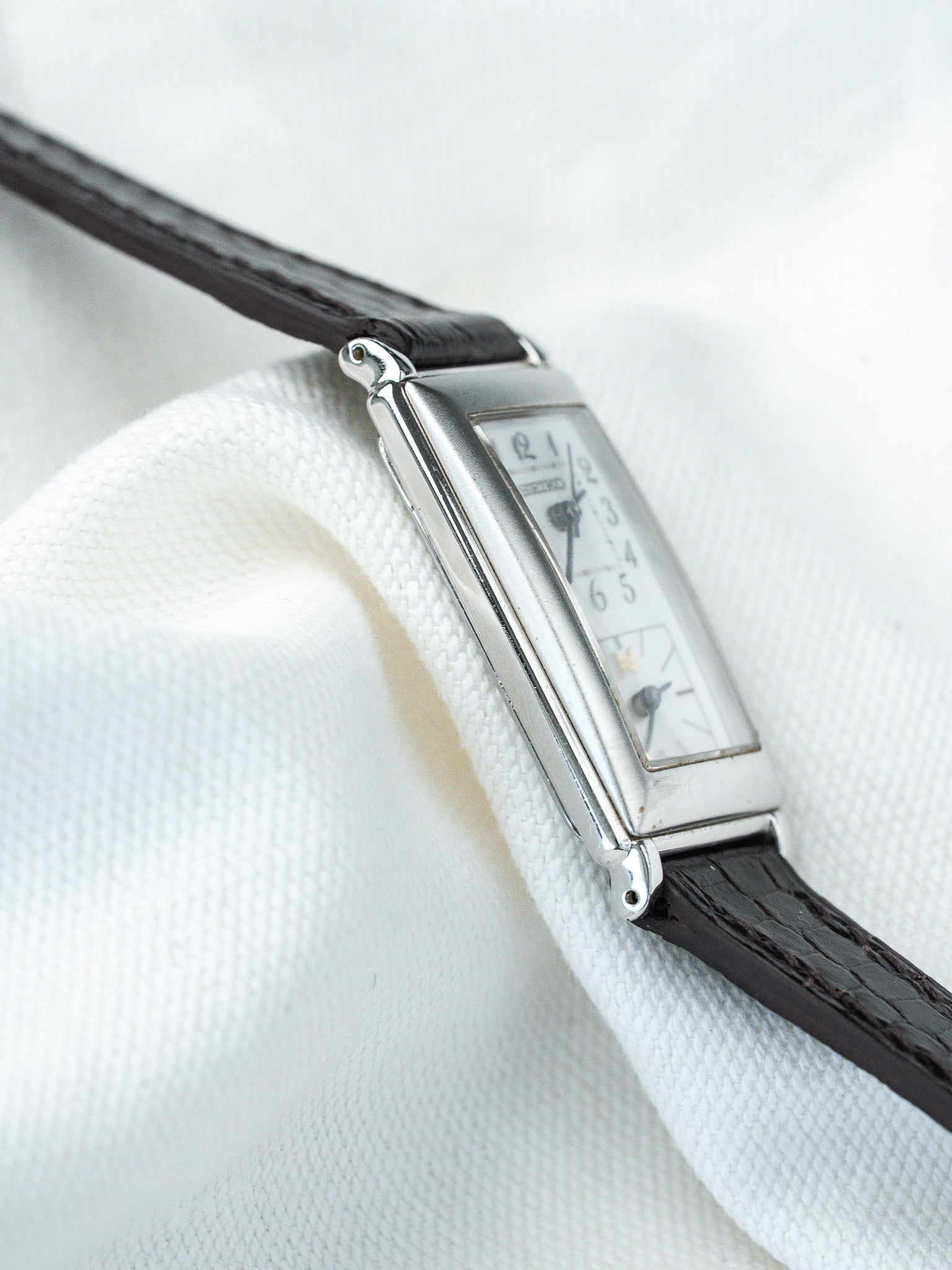 Seiko vintage rectangular watch with white dial, black leather strap on white fabric