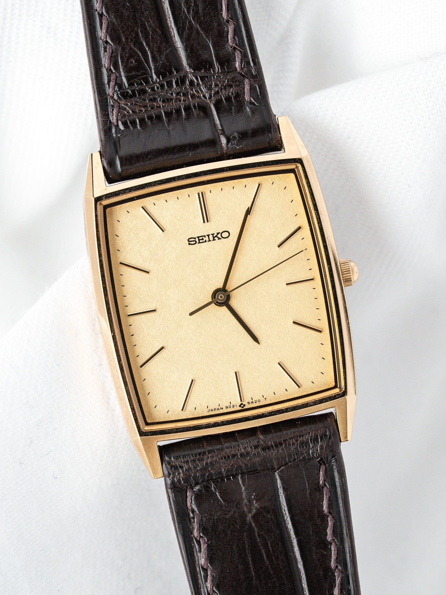 Seiko vintage watch with gold case, cream dial, and dark brown alligator strap