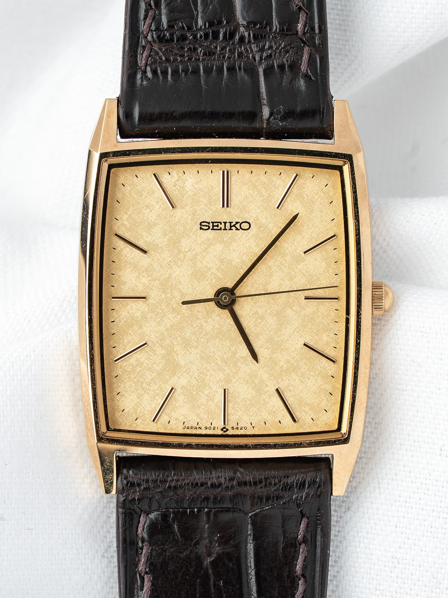 Seiko vintage watch with gold case, textured dial, and black crocodile strap