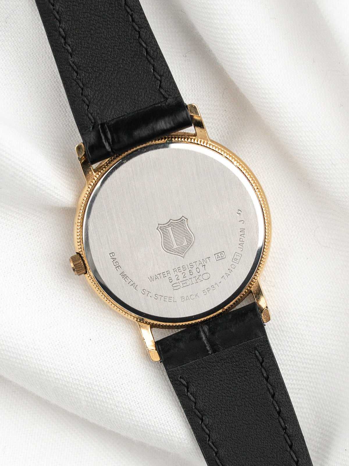 Dos d'une montre Seiko en acier inoxydable avec bracelet en cuir noir.
