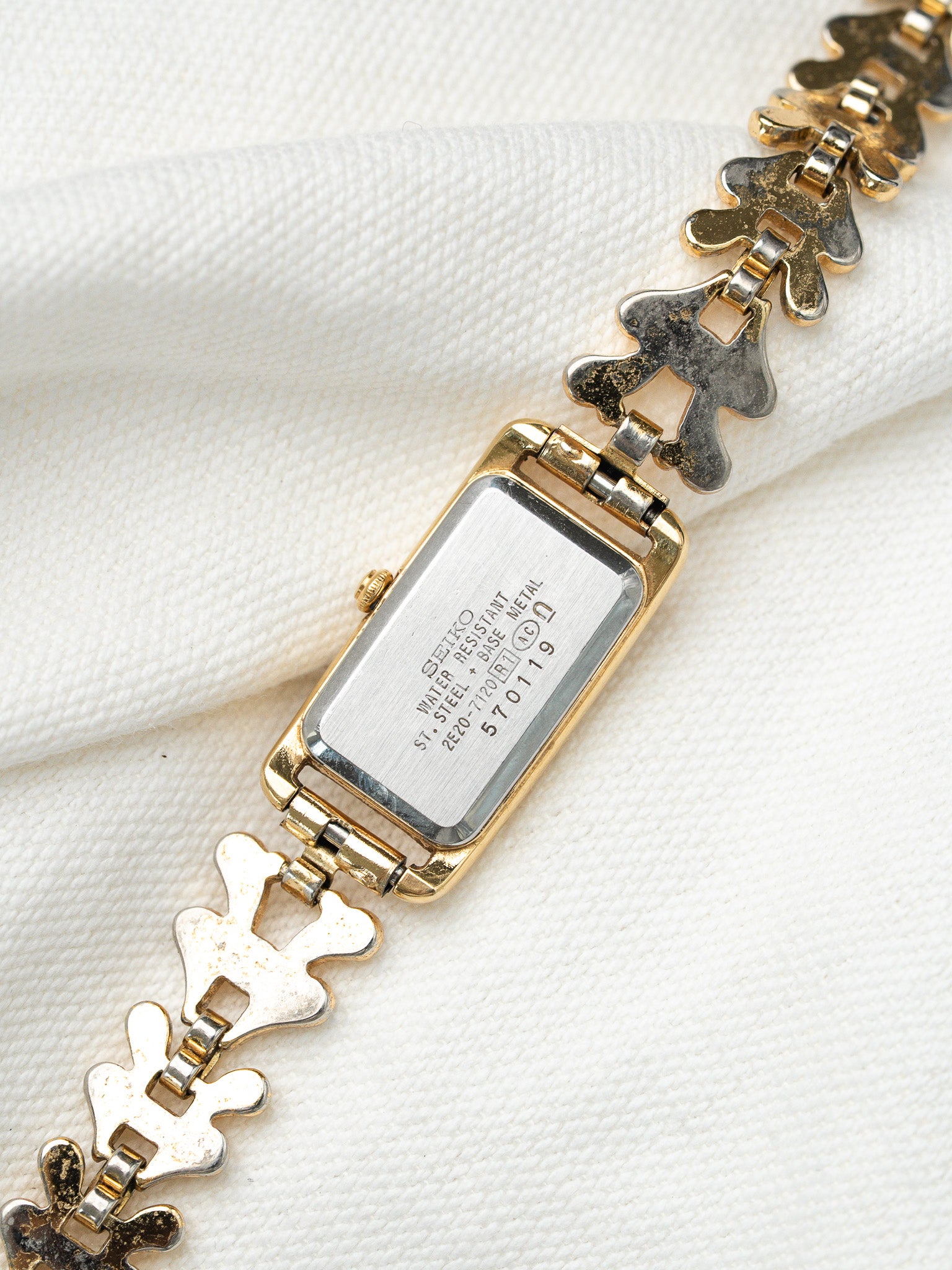 Seiko vintage watch with gold case and distinctive link bracelet on white fabric