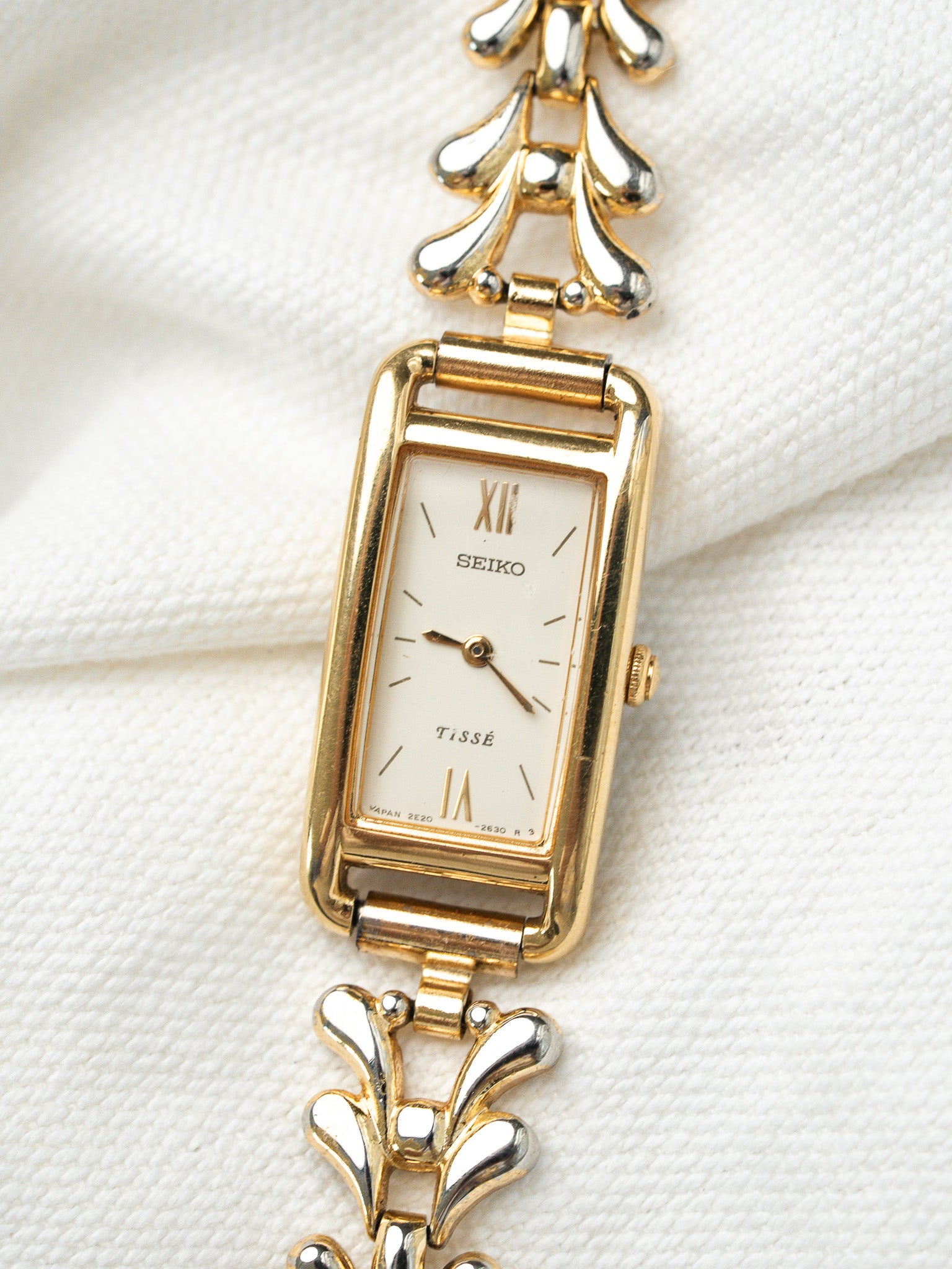 Seiko Tissé vintage watch with gold case, white dial, Roman numerals, and two-tone bracelet