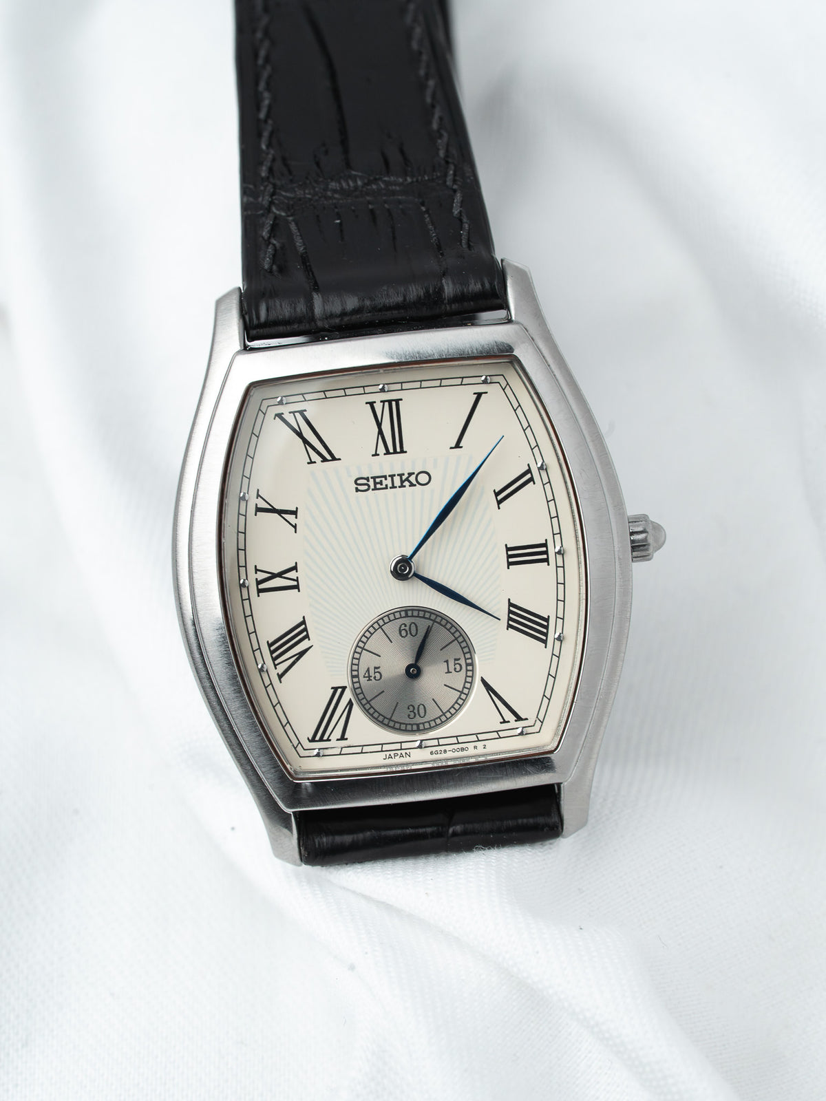 Seiko vintage watch with silver case, cream dial, Roman numerals, black leather strap