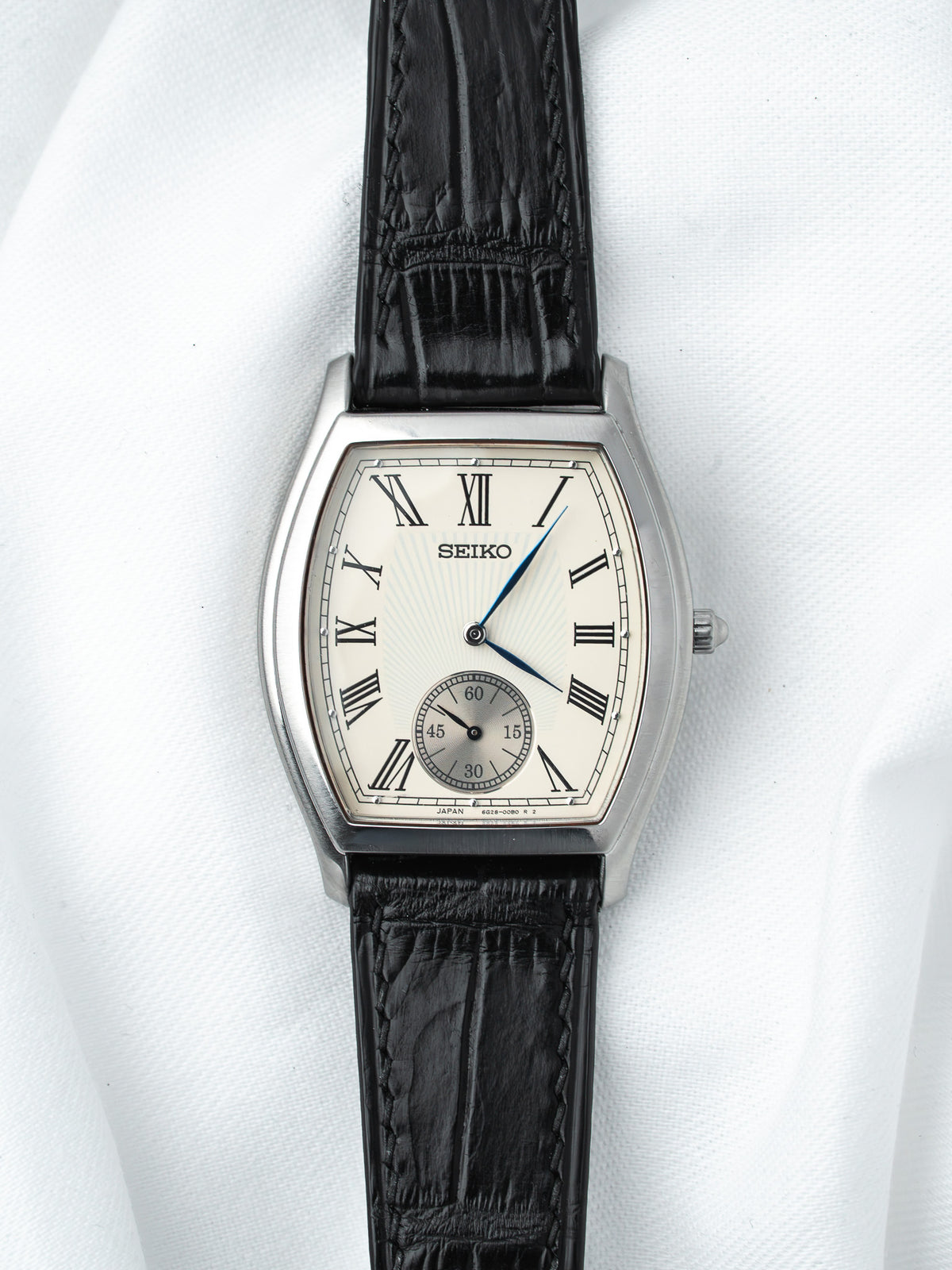 Seiko vintage watch with silver case, cream dial, Roman numerals, black leather strap