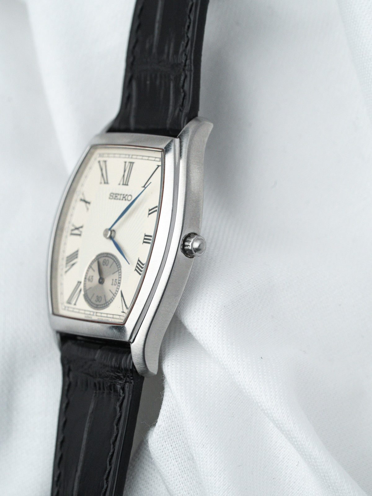 Seiko vintage watch with silver case, white dial, Roman numerals, black leather strap