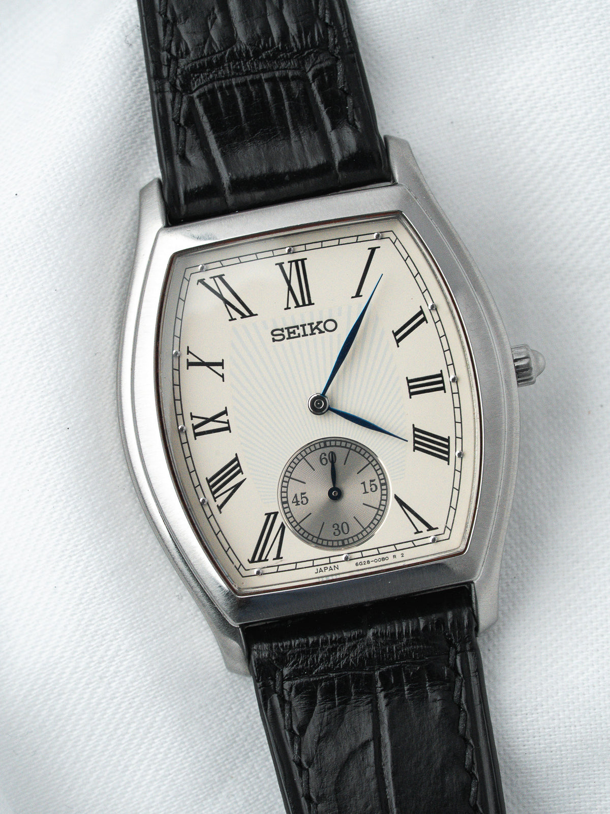 Seiko vintage watch with silver case, white dial, Roman numerals, black leather strap