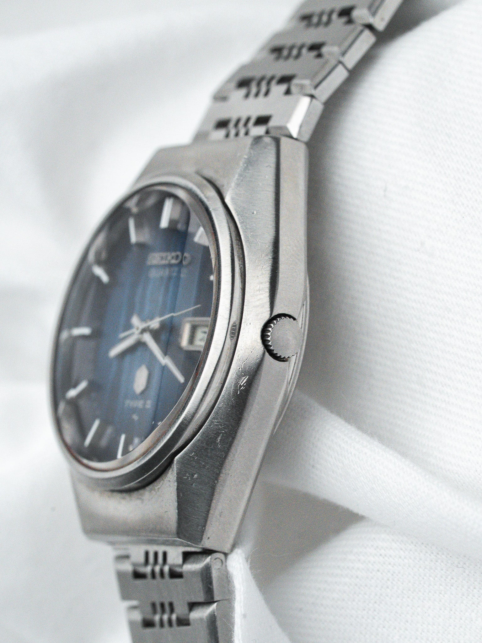 Seiko vintage watch with blue dial, stainless steel case and bracelet, displayed on white fabric