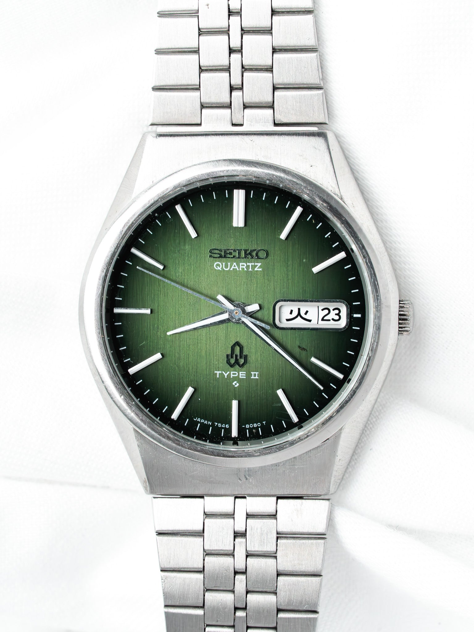Seiko Quartz Type II vintage watch with green dial and steel bracelet on white background