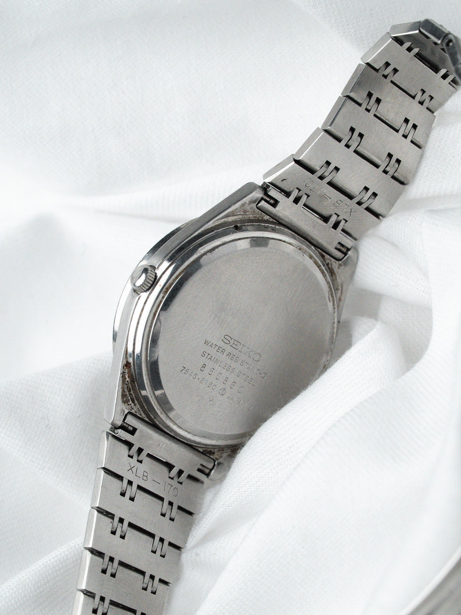 Seiko vintage watch back stainless steel with engraved model details on white fabric
