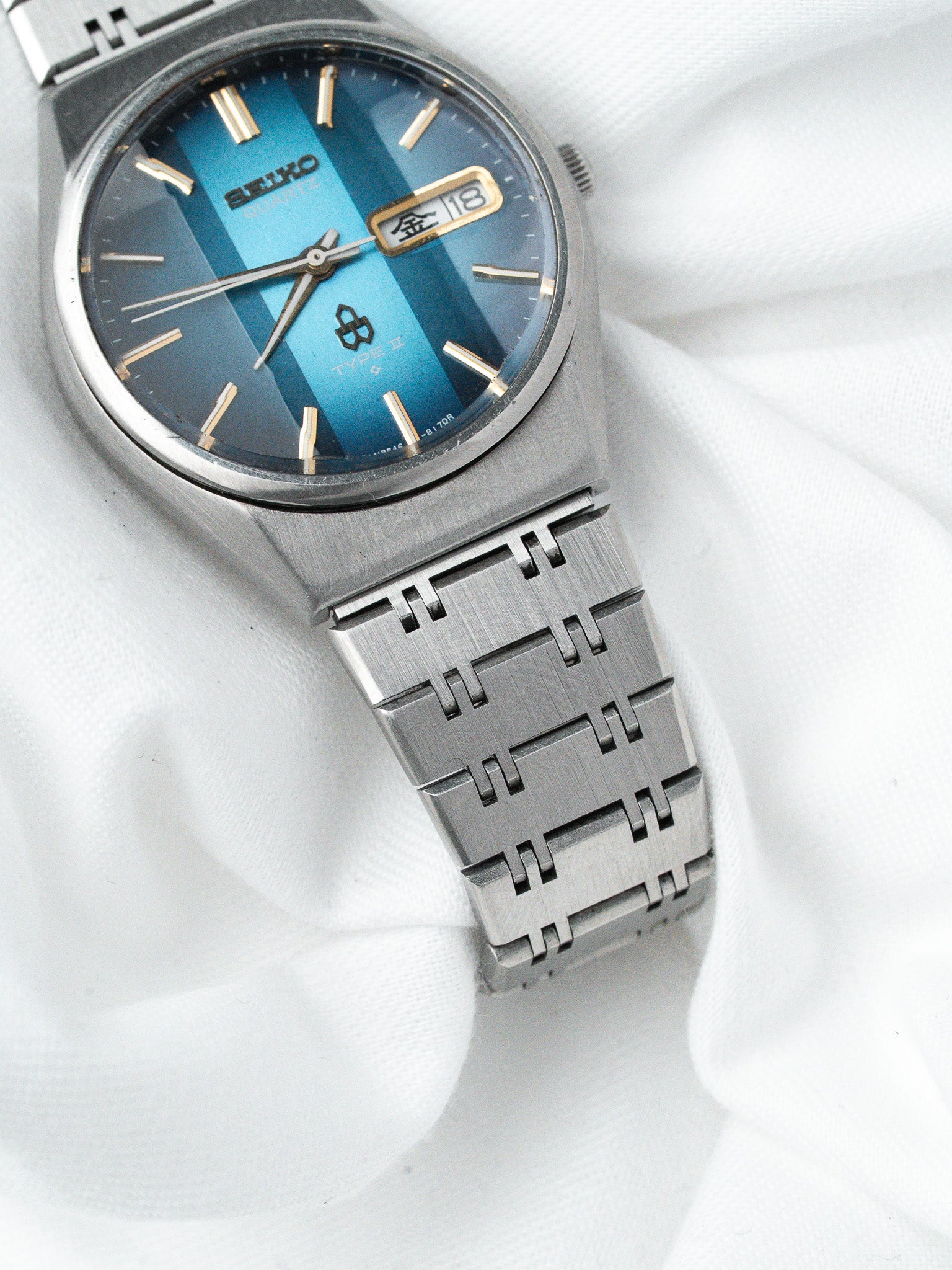 Seiko Type II vintage watch with blue striped dial and steel bracelet on white fabric