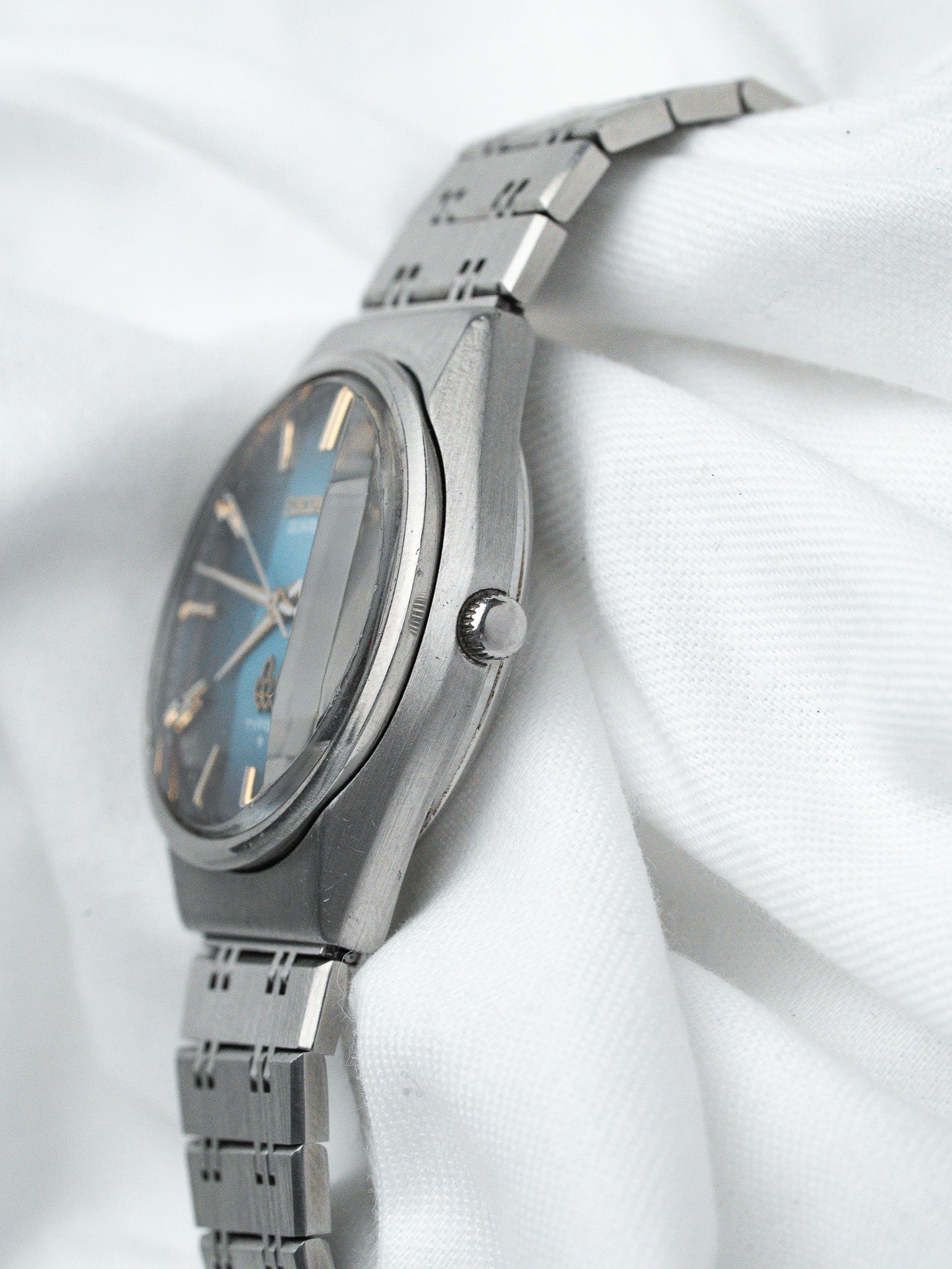 Vintage Seiko watch with blue dial, steel case and bracelet on white fabric