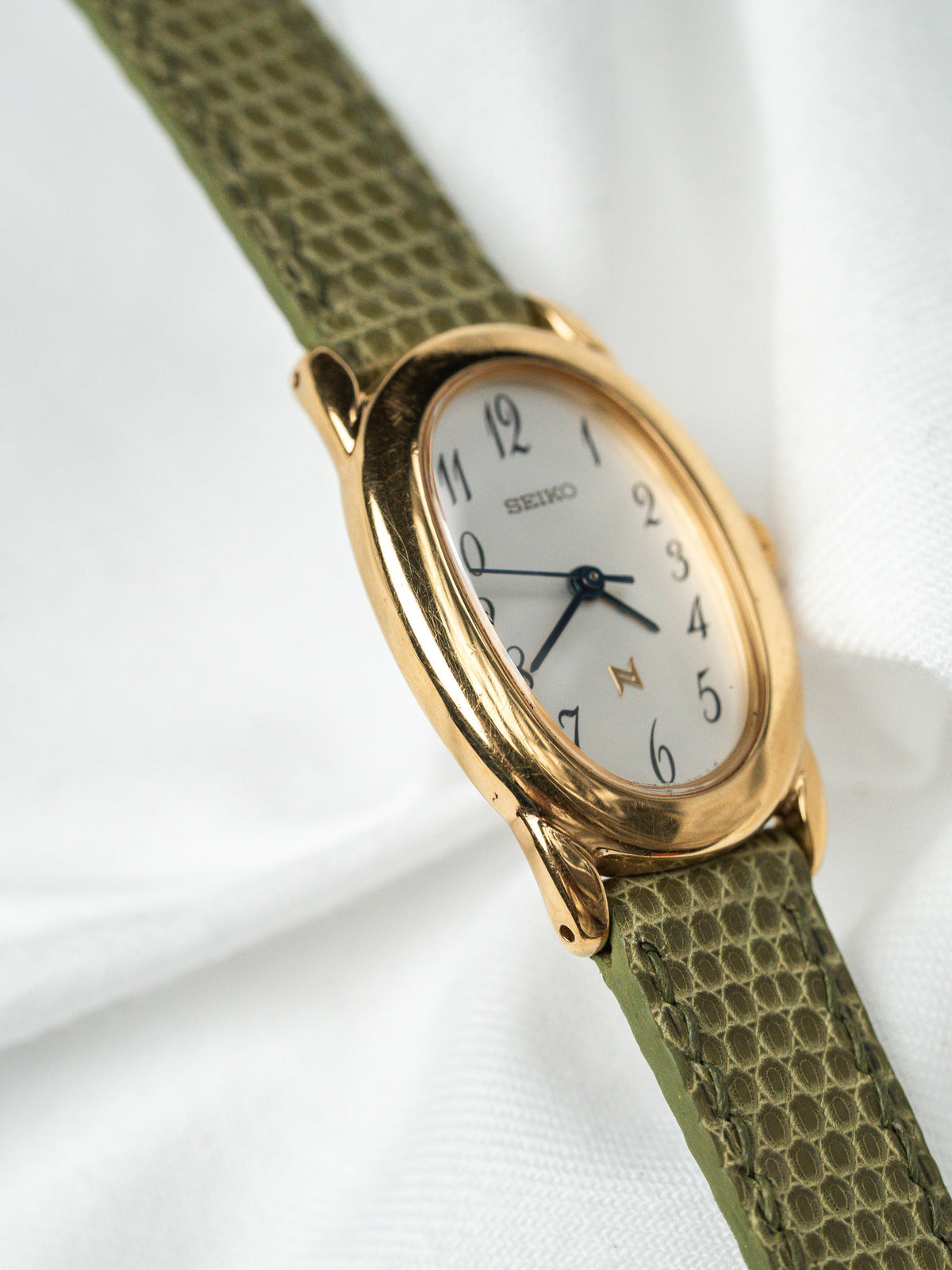 Flancs galbés du boîtier, vue inclinée - Montre Seiko 1F21-5B70 plaqué or - Atelier Victor