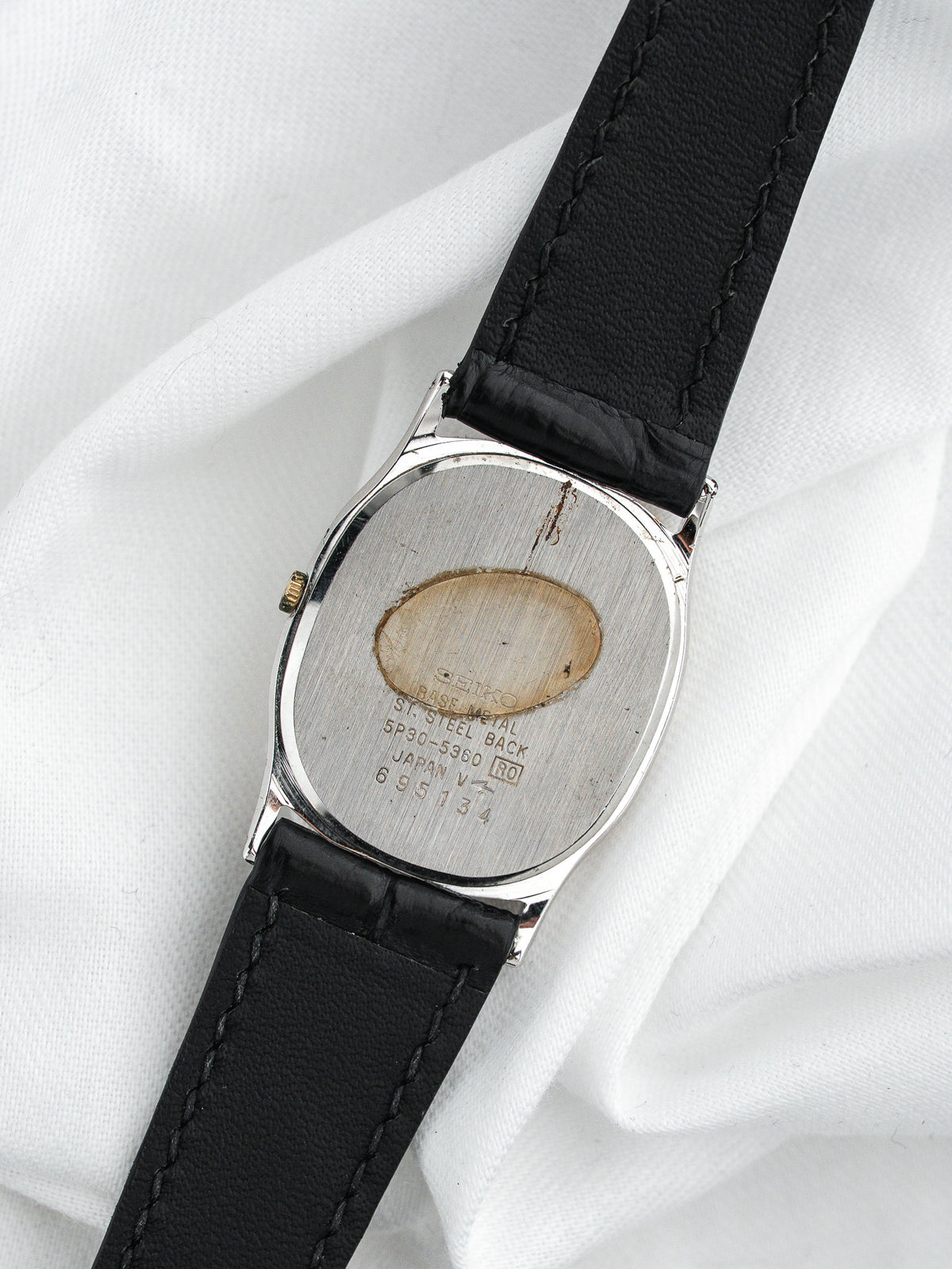 Dos d'une montre Seiko vintage en acier avec bracelet en cuir noir