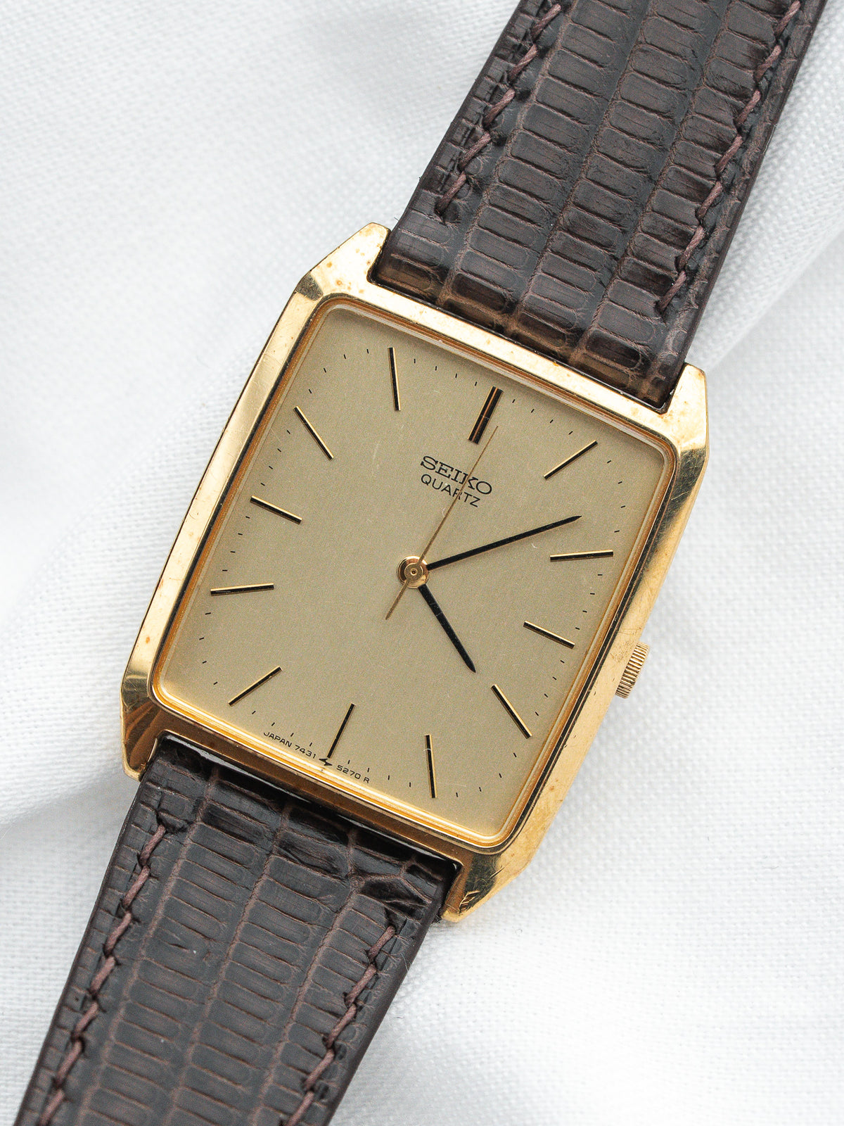Seiko Quartz vintage watch with gold case, beige dial, and brown leather strap