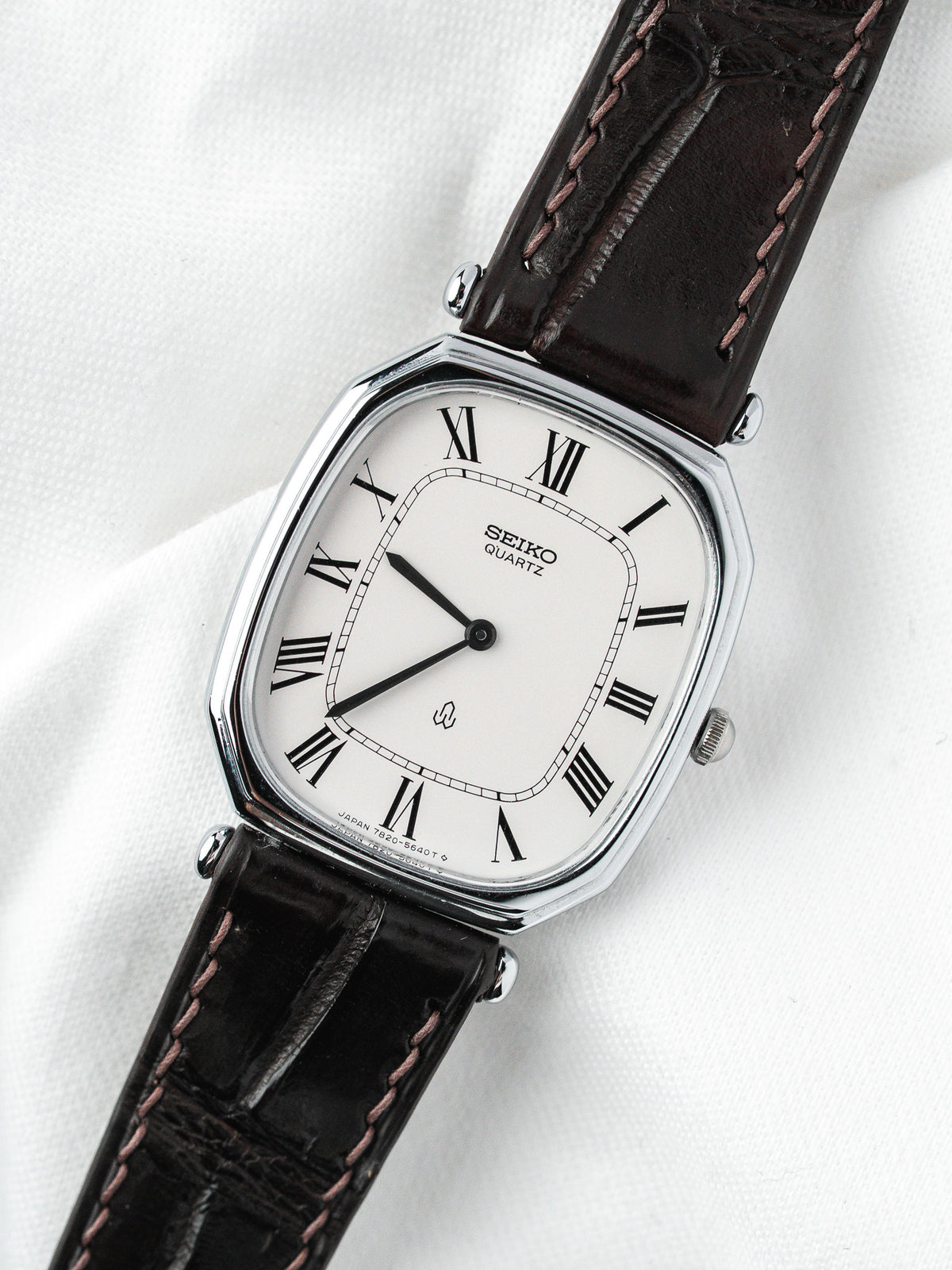 Montre Seiko Quartz vintage, boîtier rectangulaire argenté, cadran blanc et bracelet cuir marron