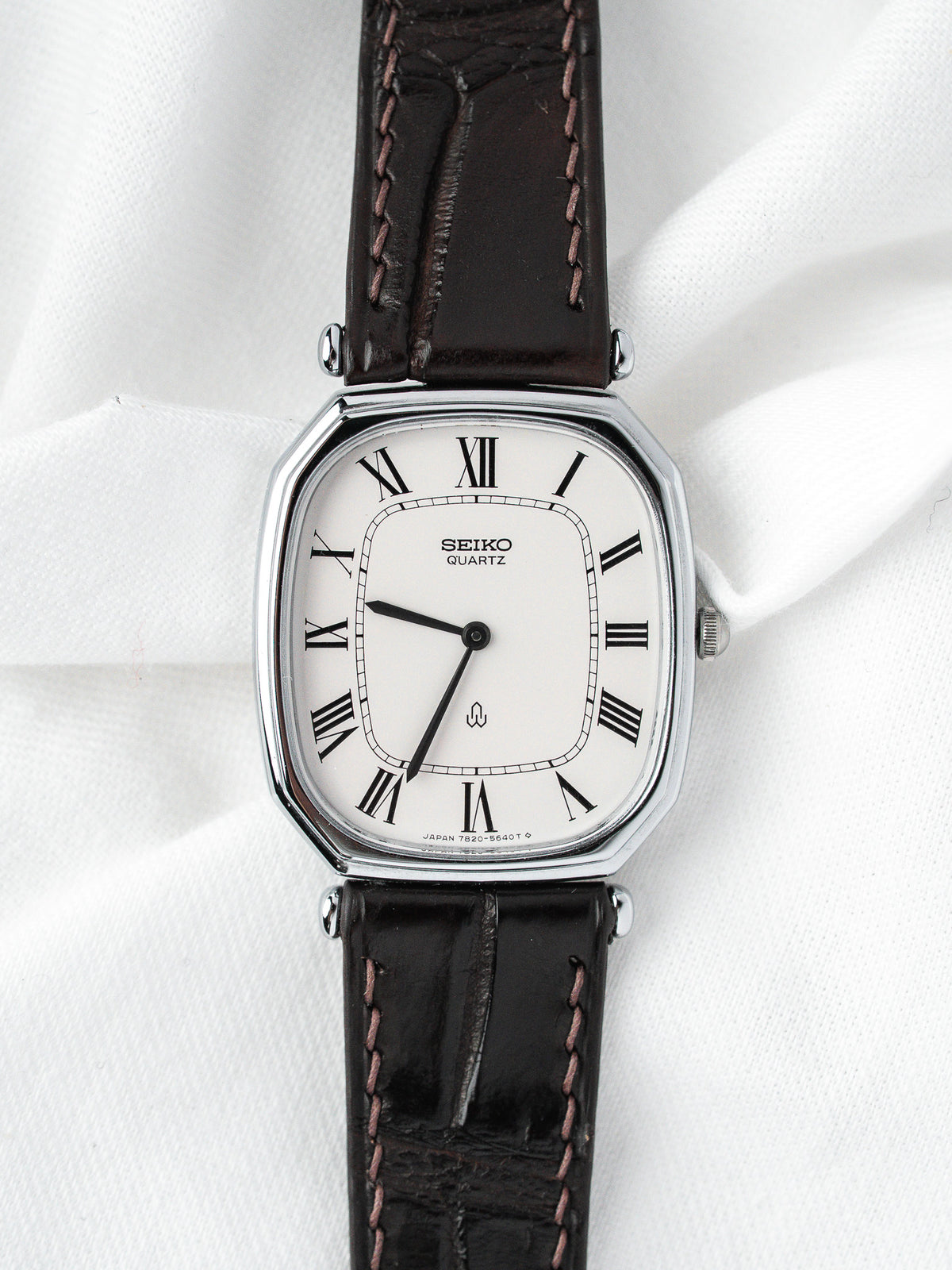 Montre Seiko vintage, boîtier rectangulaire argenté, cadran blanc et bracelet cuir marron
