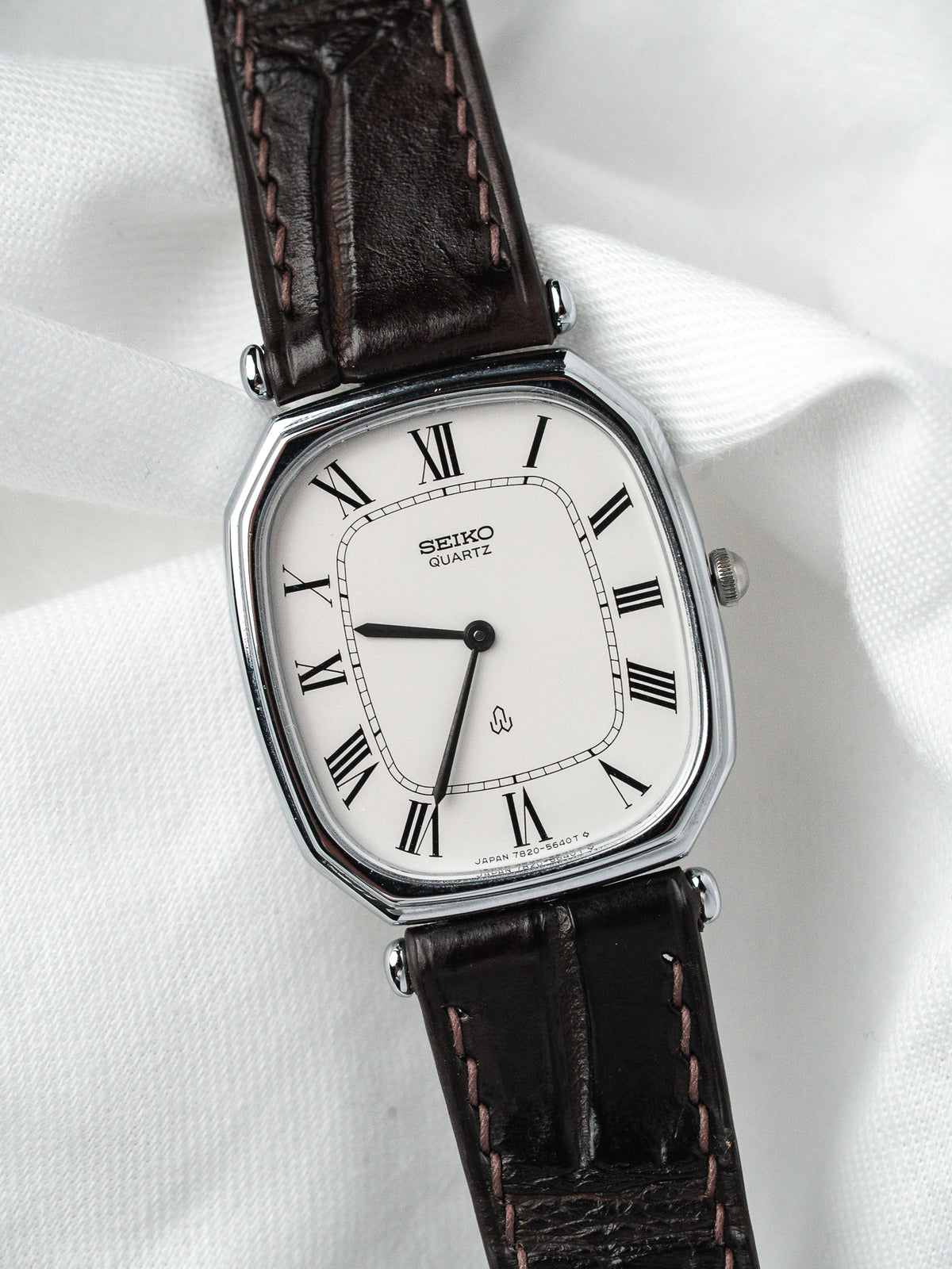 Montre Seiko Quartz vintage, boîtier rectangulaire argenté, cadran blanc et bracelet cuir marron