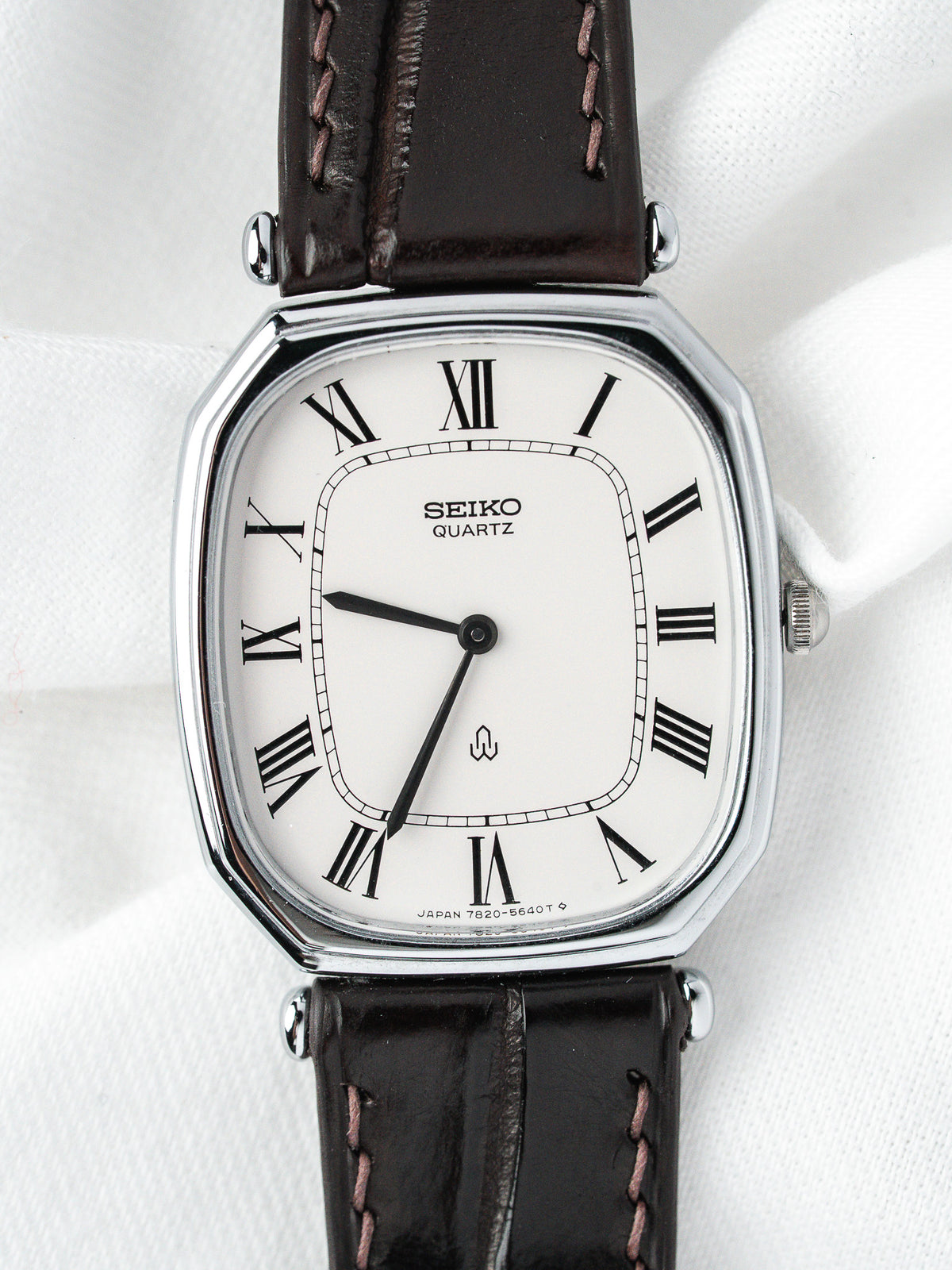 Montre Seiko Quartz vintage, boîtier rectangulaire argenté, cadran blanc et bracelet cuir marron