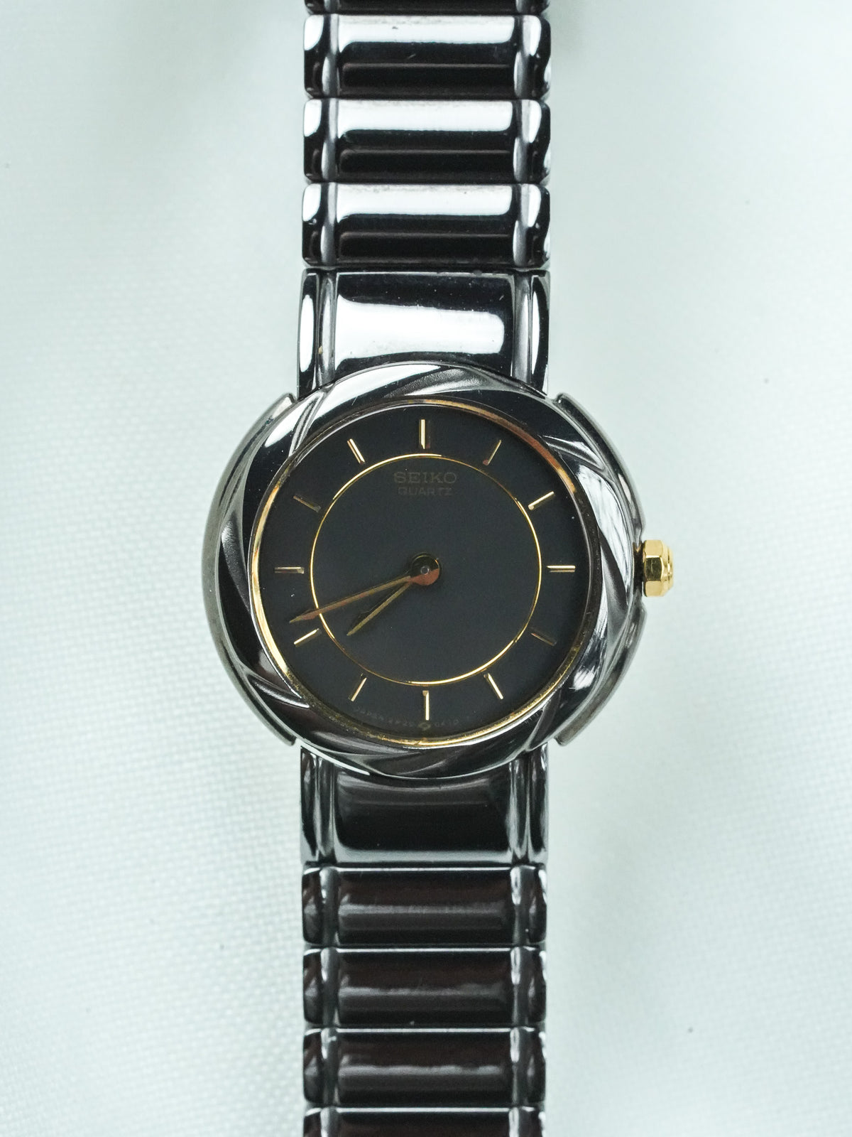 Seiko Quartz vintage watch with black dial, gold accents, and textured metal bracelet