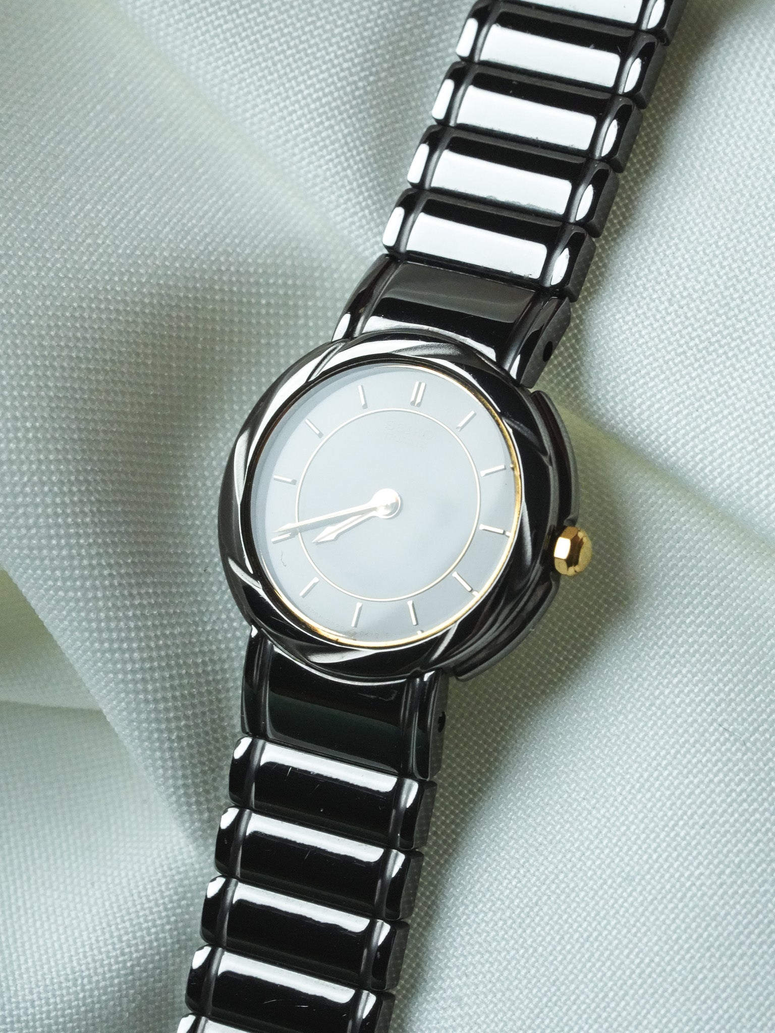 Montre vintage Seiko en céramique noire, cadran gris clair, bracelet maille