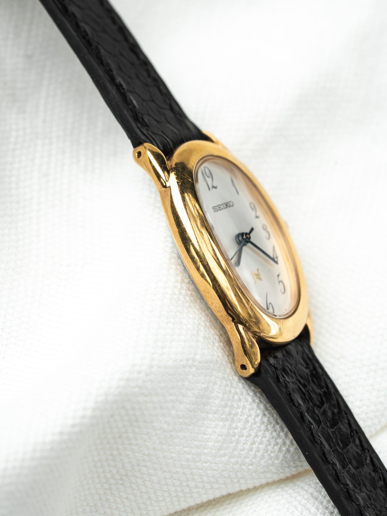 Seiko vintage watch with gold case, white dial, black leather strap