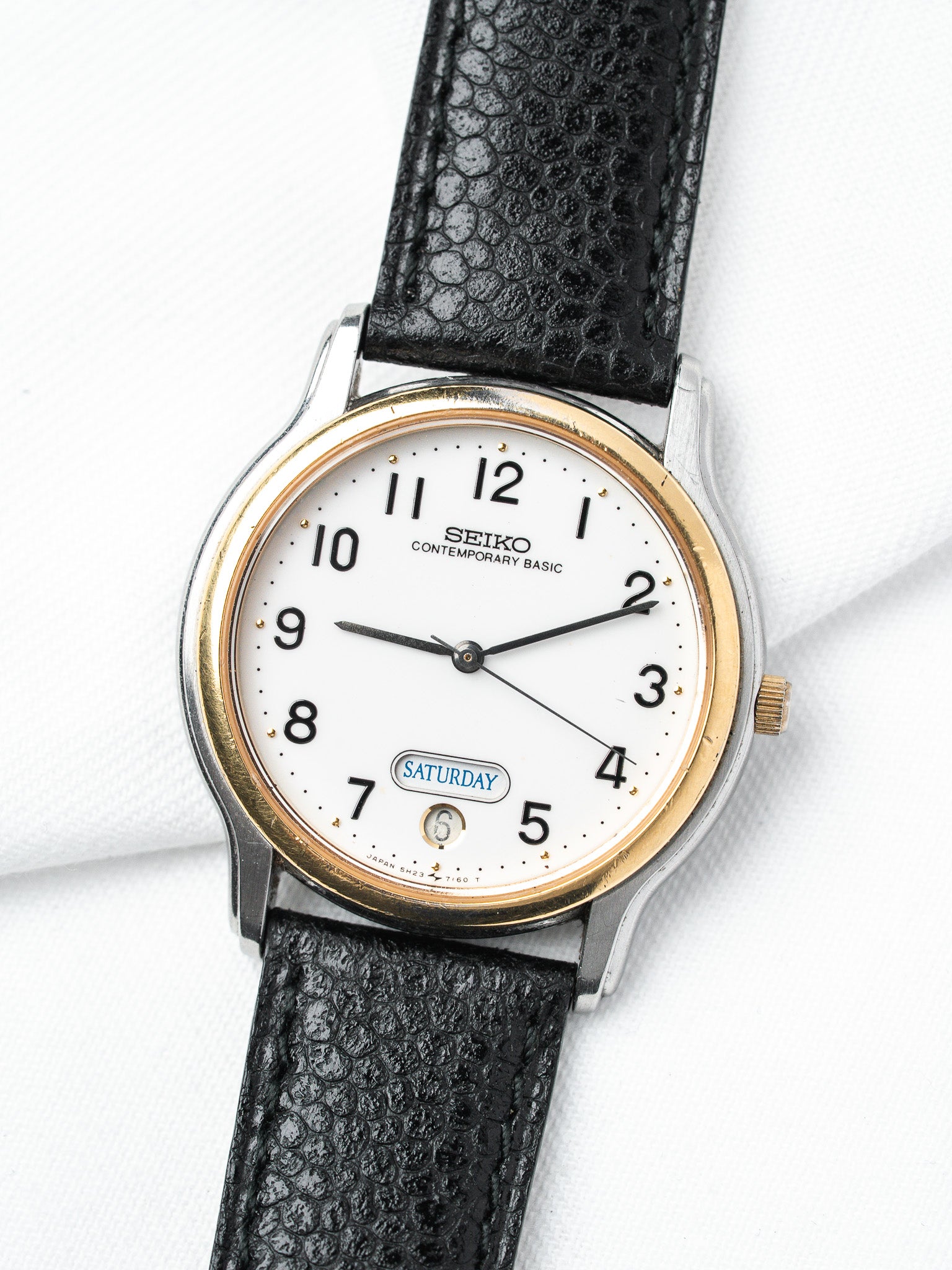 ساعة Seiko فينتاج ثنائي اللون — يوم-تاريخ قرص أبيض (ثمانينيات القرن العشرين)