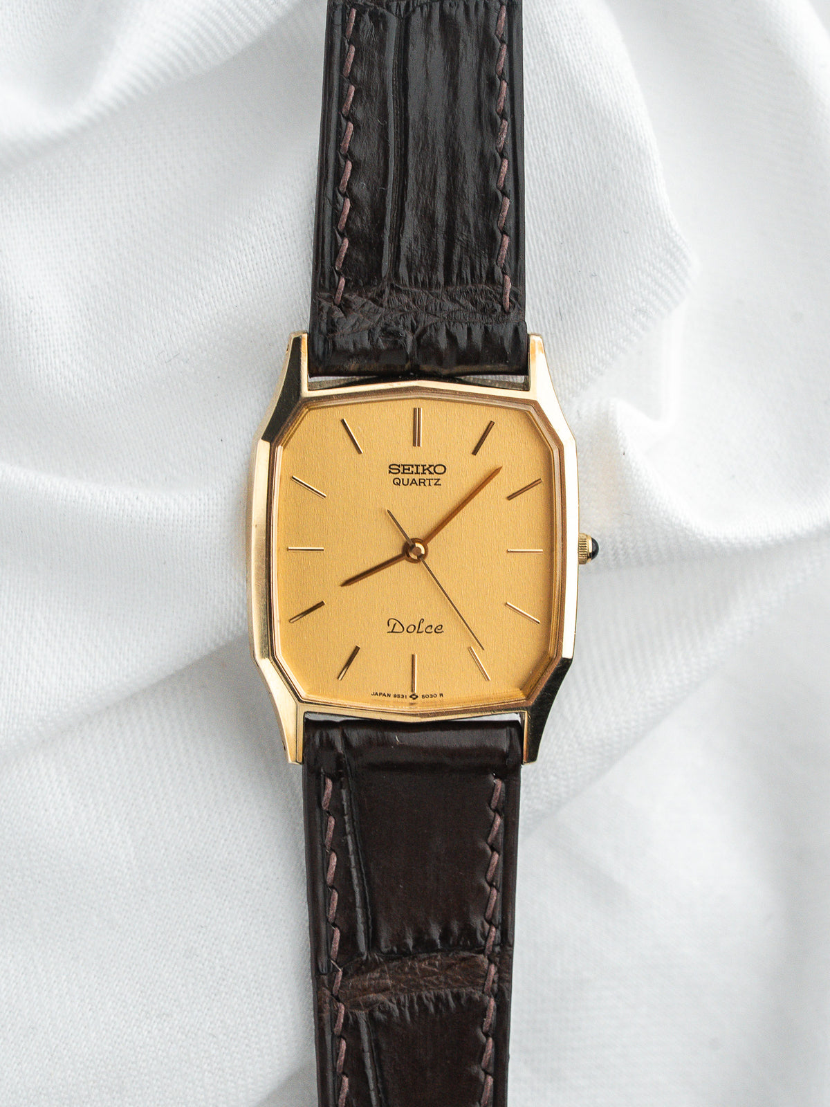 Montre Seiko Dolce vintage, boîtier octogonal doré, cadran doré et bracelet cuir marron