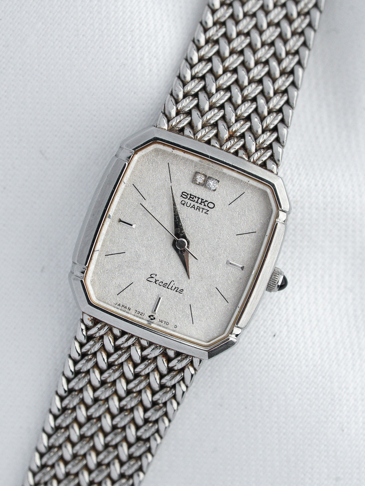 Seiko Exceline vintage quartz watch with silver dial, diamond markers, and mesh bracelet