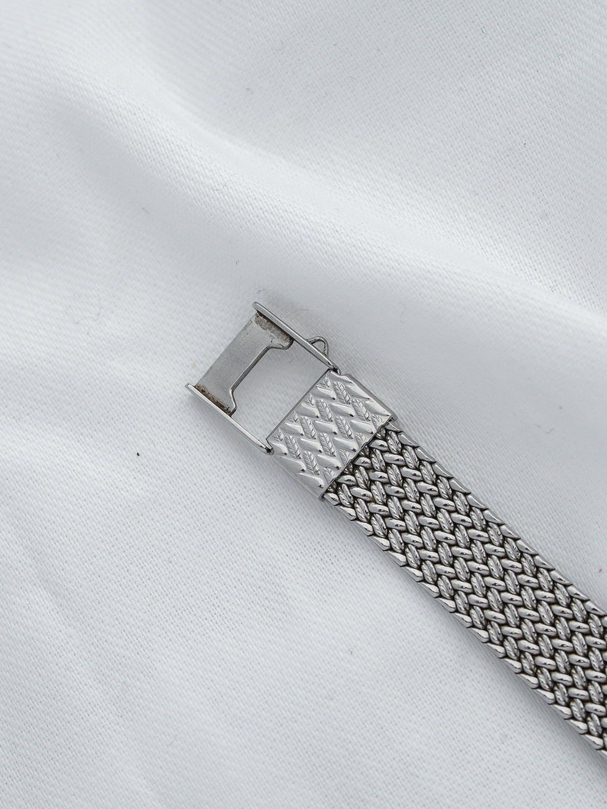 Vintage metal watch bracelet with textured mesh design and engraved clasp