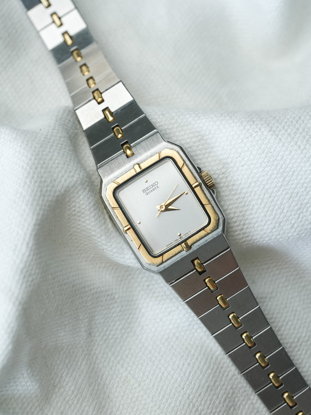 Seiko Quartz vintage watch with silver dial, gold accents, and two-tone metal bracelet