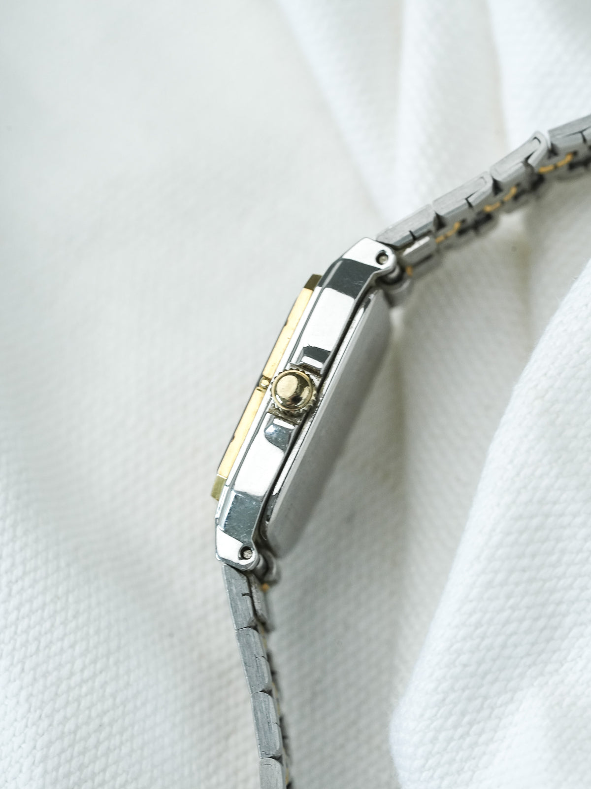 Cartier Tank vintage watch with two-tone steel and gold case, bracelet on white fabric