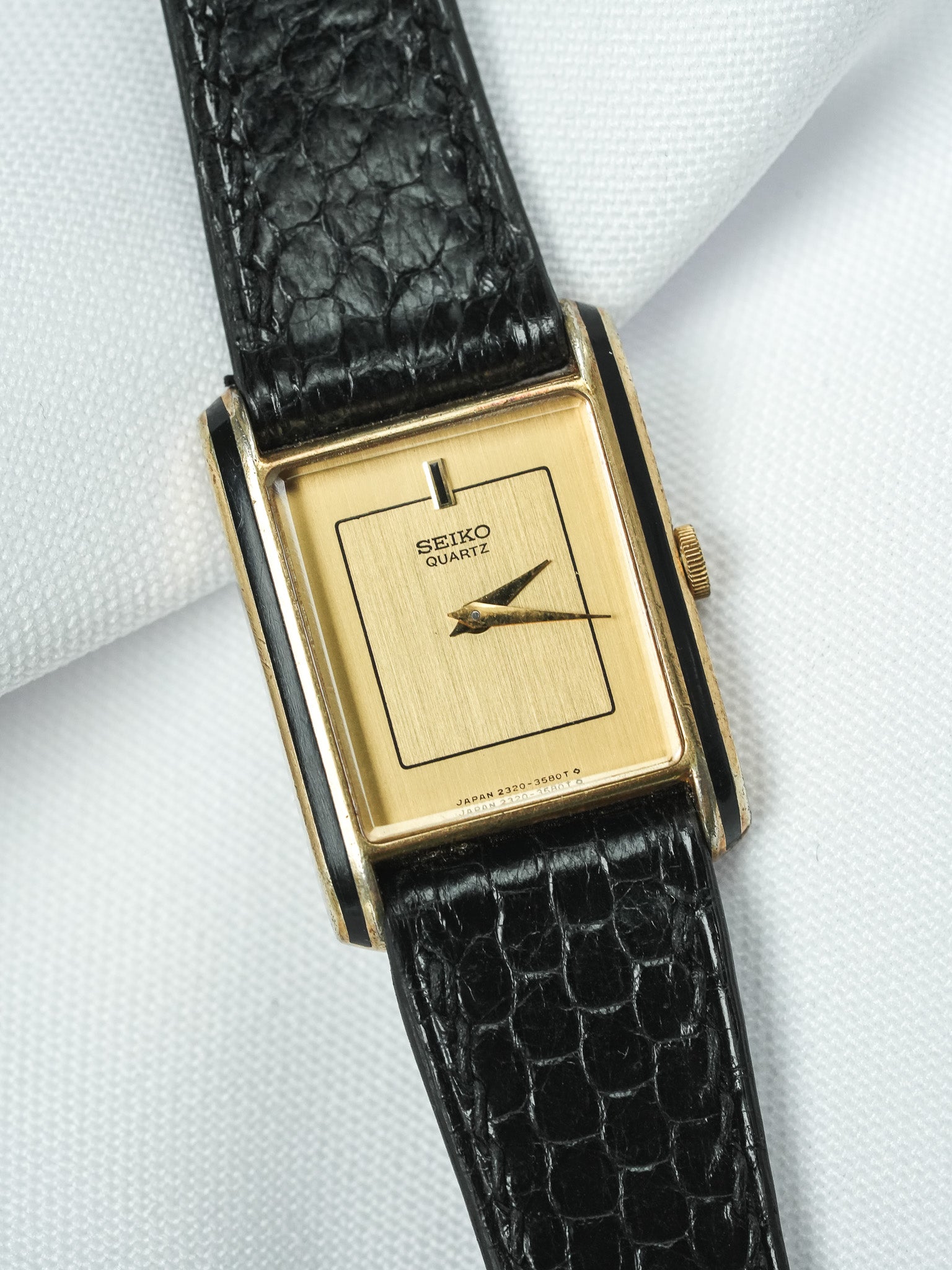 Seiko Quartz vintage watch with gold case, black leather strap, and minimalist dial